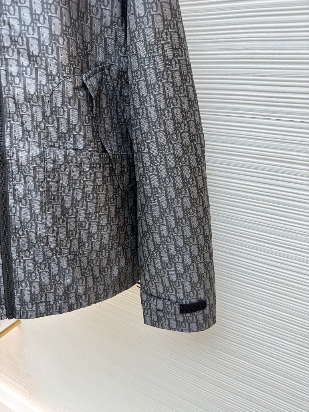 Dior Oblique full-width jacquard printed hooded jacket ●Original version: purchased and developed by 22785 ●Item number: 1681741-C45 ●Fabric: taffeta technical jacquard fabric ●Technology: printing production ●Color: gray ●Version: fitted version ●Weight: about 635 grams ●Size: S-M-L-XL ●Description: Carefully made of blue taffeta technical jacquard fabric, with front zipper closure, two flap pockets and two snap patch pockets, and a drawstring hood design for good protection. It is embellished with bee logo embroidery and can be matched with other Oblique printed items. The overall line is straight and delicate, the fabric is comfortable and soft, and the color is consistent without color difference. It can be matched with the same style to create a fashionable look and control various occasions. Customized accessories, complete with three labels, same style for men and women!