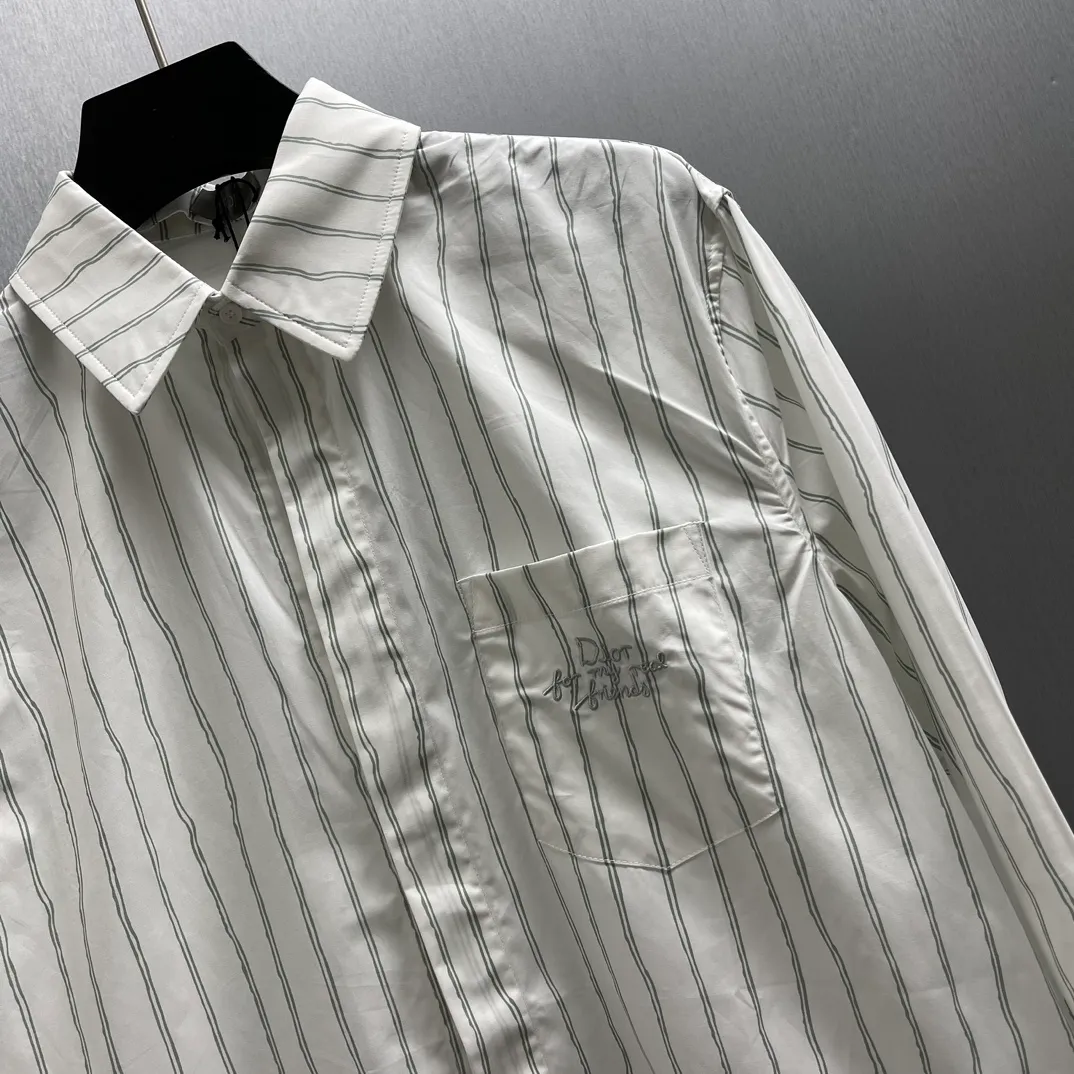 🅿️480 CD Blue and gray vertical pattern simple embroidered shirt Size: S-XL This shirt combines modern style with traditional beauty. Crafted from white cotton poplin, it features a blue and gray striped pattern displaying the Dior For My Real Friends signature from the DIOR AND HYLTON NE collection. A patch pocket on the chest and hidden button closure complete the design. Can be worn with everyday clothing.