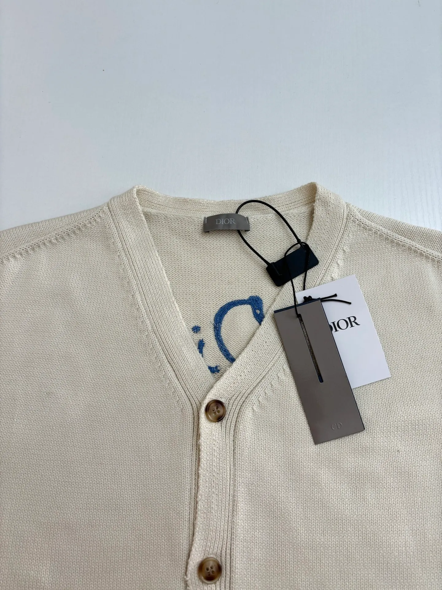 🅿️500 Dio*/Dior 25Fw new friend embroidered cotton blend button cardigan. The fabric is made of 40-count cotton yarn and wool, and the cotton content is 62%. It is mixed with 38% polyester. Mixing two kinds of wool materials can effectively make the upper body more three-dimensional. The embroidery uses high-density wool yarn embroidery technology, and the front numbers are all equipped with the joint series embroidery LOGO. The number of stitches is about 12,000. The auxiliary buttons are made of natural horn buttons, with the brand's iconic [DIOR] LOGO on the buttons. This cardigan displays the Dior For My Real Friends logo from the DIOR AND HYLTON NEL collaboration. Crafted from white cotton-blend jersey with embroidery on the front and back, button fastening and ribbed trims.  Size：S/M/L