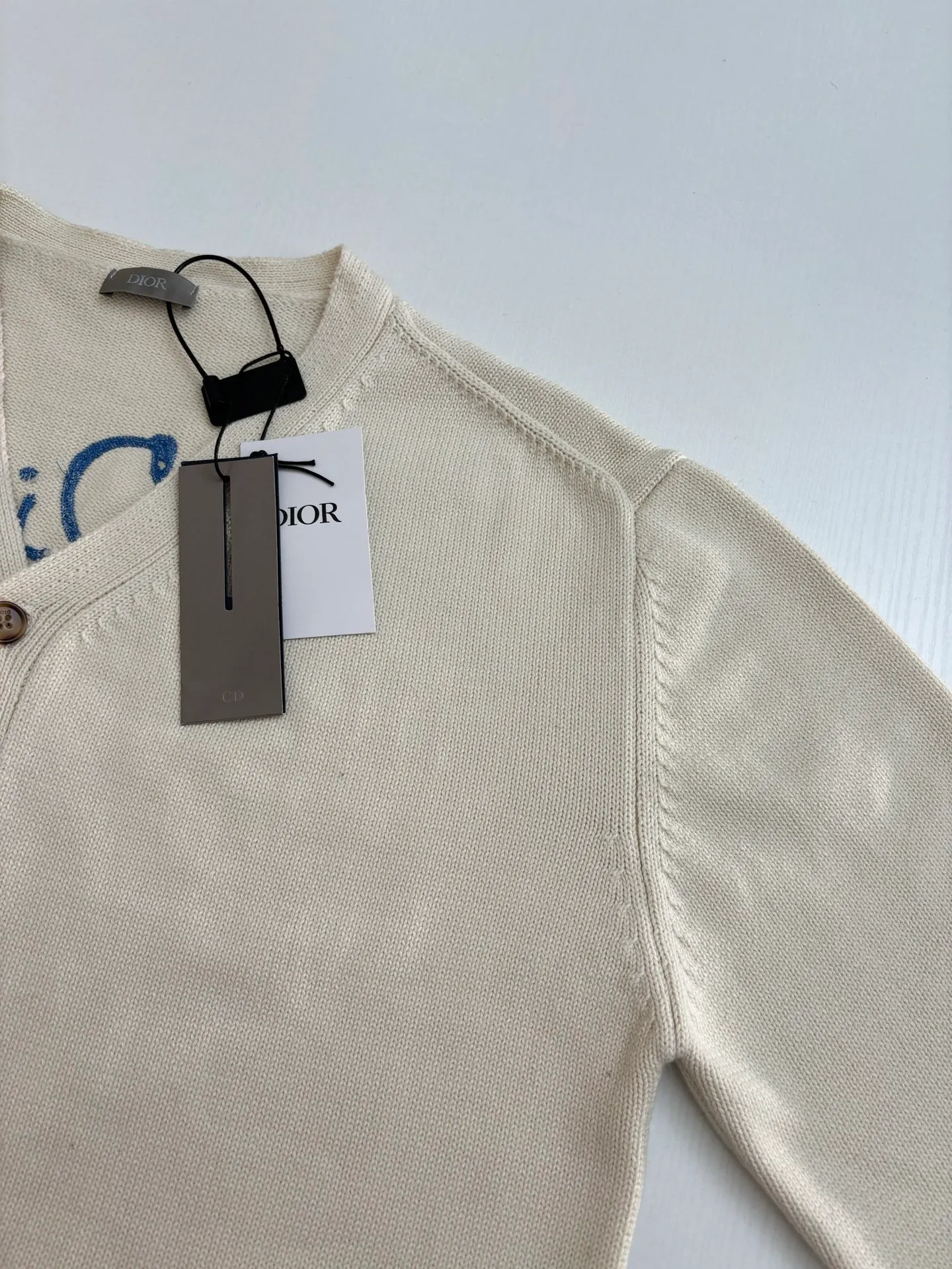 🅿️500 Dio*/Dior 25Fw new friend embroidered cotton blend button cardigan. The fabric is made of 40-count cotton yarn and wool, and the cotton content is 62%. It is mixed with 38% polyester. Mixing two kinds of wool materials can effectively make the upper body more three-dimensional. The embroidery uses high-density wool yarn embroidery technology, and the front numbers are all equipped with the joint series embroidery LOGO. The number of stitches is about 12,000. The auxiliary buttons are made of natural horn buttons, with the brand's iconic [DIOR] LOGO on the buttons. This cardigan displays the Dior For My Real Friends logo from the DIOR AND HYLTON NEL collaboration. Crafted from white cotton-blend jersey with embroidery on the front and back, button fastening and ribbed trims.  Size：S/M/L