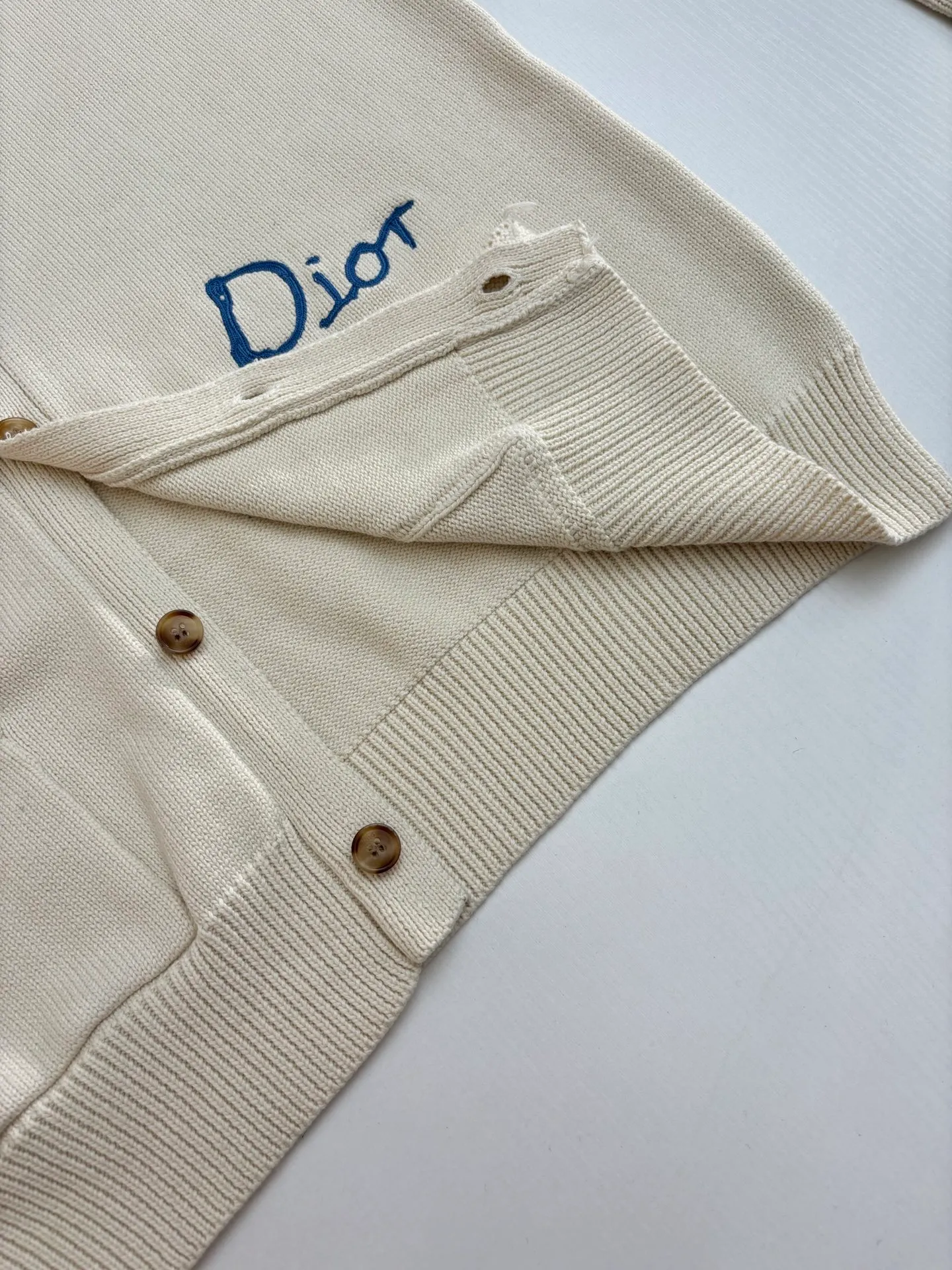 🅿️500 Dio*/Dior 25Fw new friend embroidered cotton blend button cardigan. The fabric is made of 40-count cotton yarn and wool, and the cotton content is 62%. It is mixed with 38% polyester. Mixing two kinds of wool materials can effectively make the upper body more three-dimensional. The embroidery uses high-density wool yarn embroidery technology, and the front numbers are all equipped with the joint series embroidery LOGO. The number of stitches is about 12,000. The auxiliary buttons are made of natural horn buttons, with the brand's iconic [DIOR] LOGO on the buttons. This cardigan displays the Dior For My Real Friends logo from the DIOR AND HYLTON NEL collaboration. Crafted from white cotton-blend jersey with embroidery on the front and back, button fastening and ribbed trims.  Size：S/M/L
