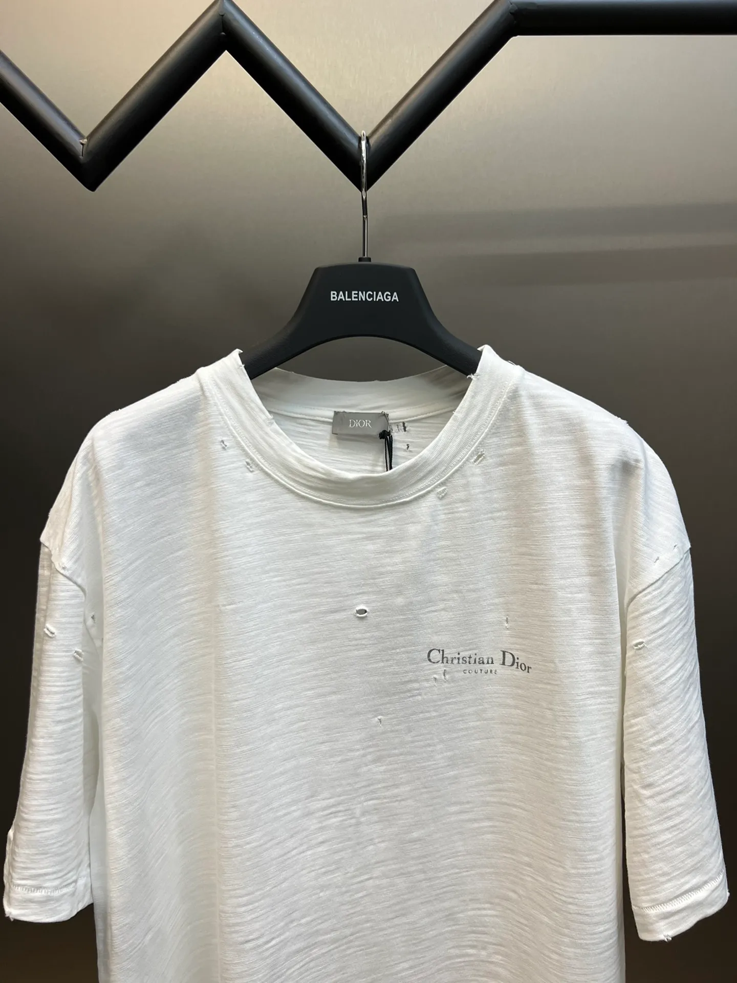 🅿️330 Dior ripped letter print short sleeves The fabric is made of 10s pure cotton slub plain fabric with a weight of 310g. This fabric is used as the collar, and the round collar is manually positioned on a flat machine. The front and back panels are printed with hand-made platen silk screen glue, and the film is engraved with laser dots to create a hollowed-out effect of missing letters. The clothes are designed with bifurcated sides, and the hems of the front and rear panels are cut with a special machine to pick the legs. There are lines on the surface to create a hollow effect. The entire garment is manually positioned and cut with holes, and the garment is fermented and washed to create a nostalgic effect. size：xs s m l