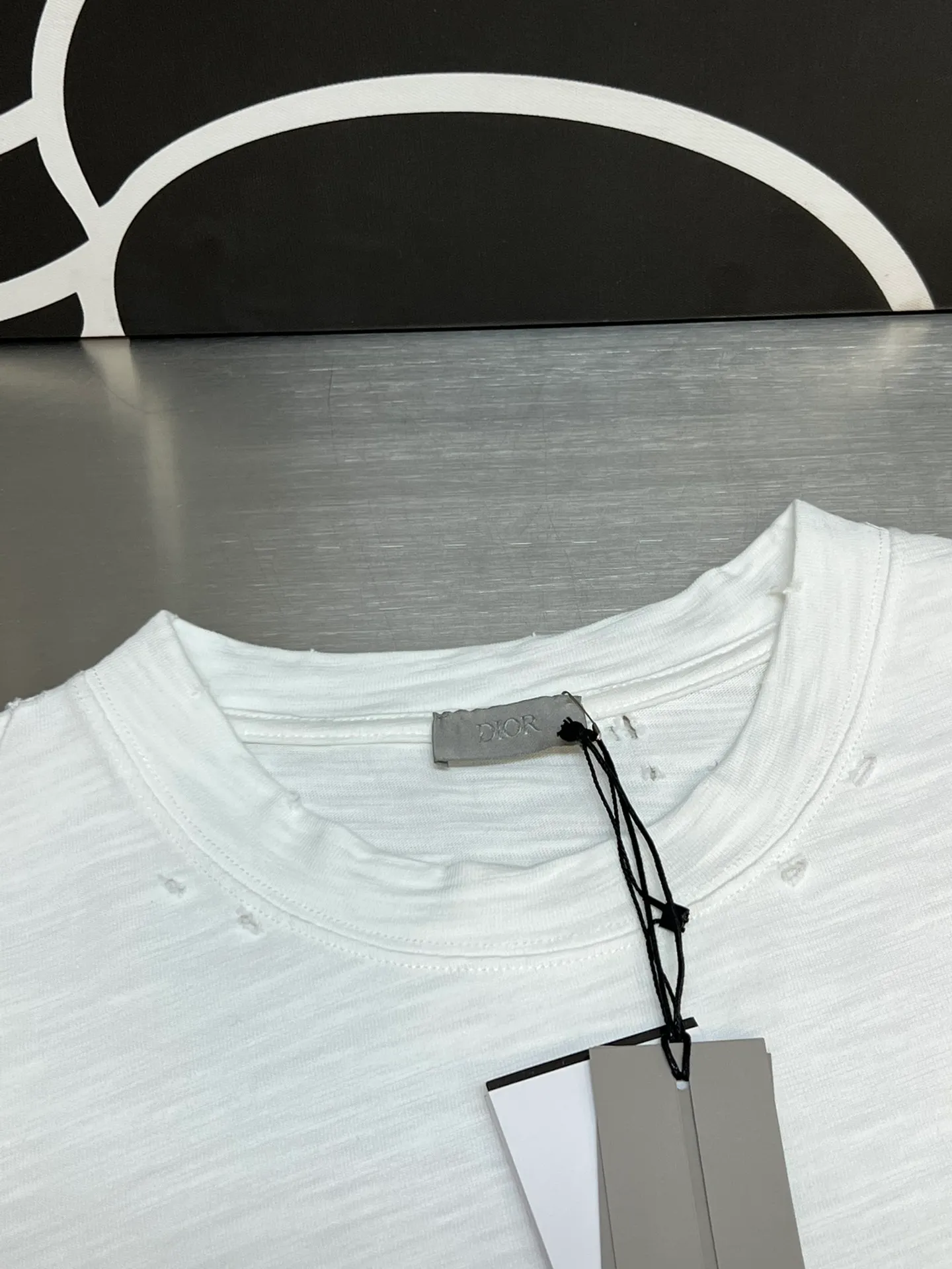 🅿️330 Dior ripped letter print short sleeves The fabric is made of 10s pure cotton slub plain fabric with a weight of 310g. This fabric is used as the collar, and the round collar is manually positioned on a flat machine. The front and back panels are printed with hand-made platen silk screen glue, and the film is engraved with laser dots to create a hollowed-out effect of missing letters. The clothes are designed with bifurcated sides, and the hems of the front and rear panels are cut with a special machine to pick the legs. There are lines on the surface to create a hollow effect. The entire garment is manually positioned and cut with holes, and the garment is fermented and washed to create a nostalgic effect. size：xs s m l