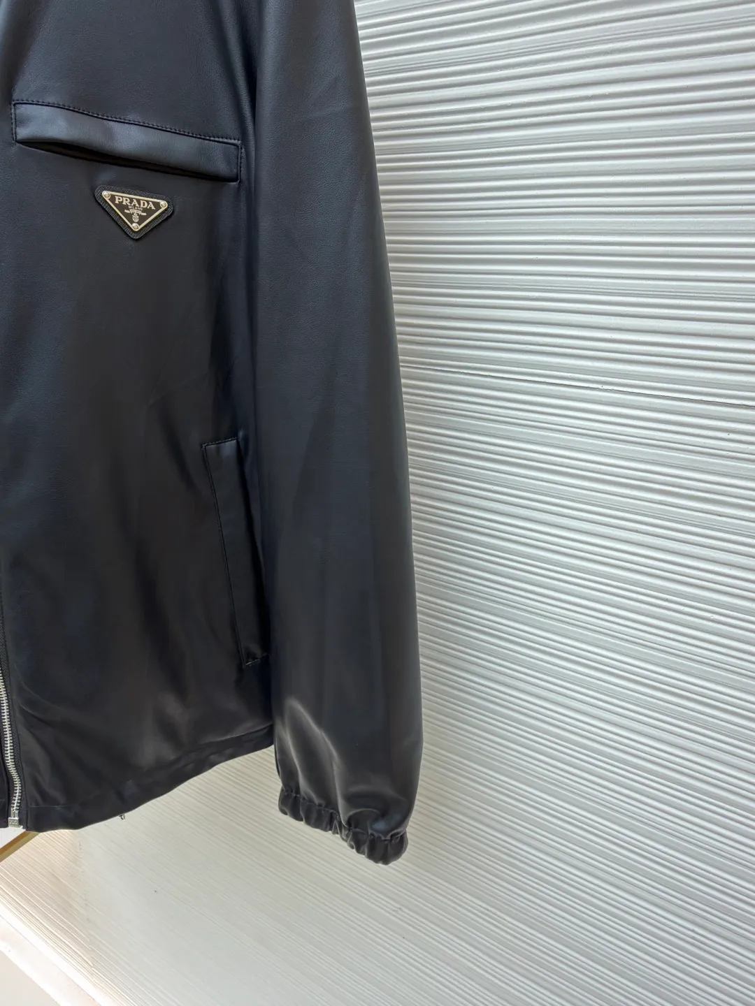Prada reversible leather nylon hooded jacket ●Original version: Purchased and developed for 41900 ●Item number: 1681458-D35 ●Material: lamb leather fabric ●Technology: draped cutting ●Color: melanin ●Version: Fitted version ●Weight: about 960 grams ●Size: 46-48-50-52 ●Description: Customized lambskin leather and rhyme-hole silky plain silk with natural texture and natural luster Comfortable and close to the skin, double-sided charm, one garment to enjoy. On one side, the distinctive leather shows the noble texture. On the other side, the simple plain grain interprets the low-key connotation. Clean lines and simple textures exude a sense of luxury from the inside out. The iconic enamel-coated triangle metal logos are respectively embellished to highlight the elegance and nobility of the brand. It is highly recognizable. The collision of flexible sheepskin and functional hood reconstructs the hard-core and casual fashion. The two-sided transformation is wonderful in itself and reflects each other. Unlock a new dimension of fashion, use imported special machine infrared to locate the "Prada triangle mark", the position is more accurate, strong and solid, ergonomic three-dimensional cutting, return to the traditional craftsmanship through segmentation, folding, shrinking and stretching technology. The so-called slow work is the respect for materials. The pursuit of feel. Complex workmanship, tedious, slow timeliness, high loss, template machine bag opening, preset template to guide the position, shape and size of the bag opening. Accuracy ensures the quality of the bag opening effect. The overall wiring is straight and delicate, the fabric is comfortable and soft, and the color is consistent without color difference. It can be matched with the same style to create a fashionable look and control various occasions. Customized accessories, complete with three standards, same style for men and women!
