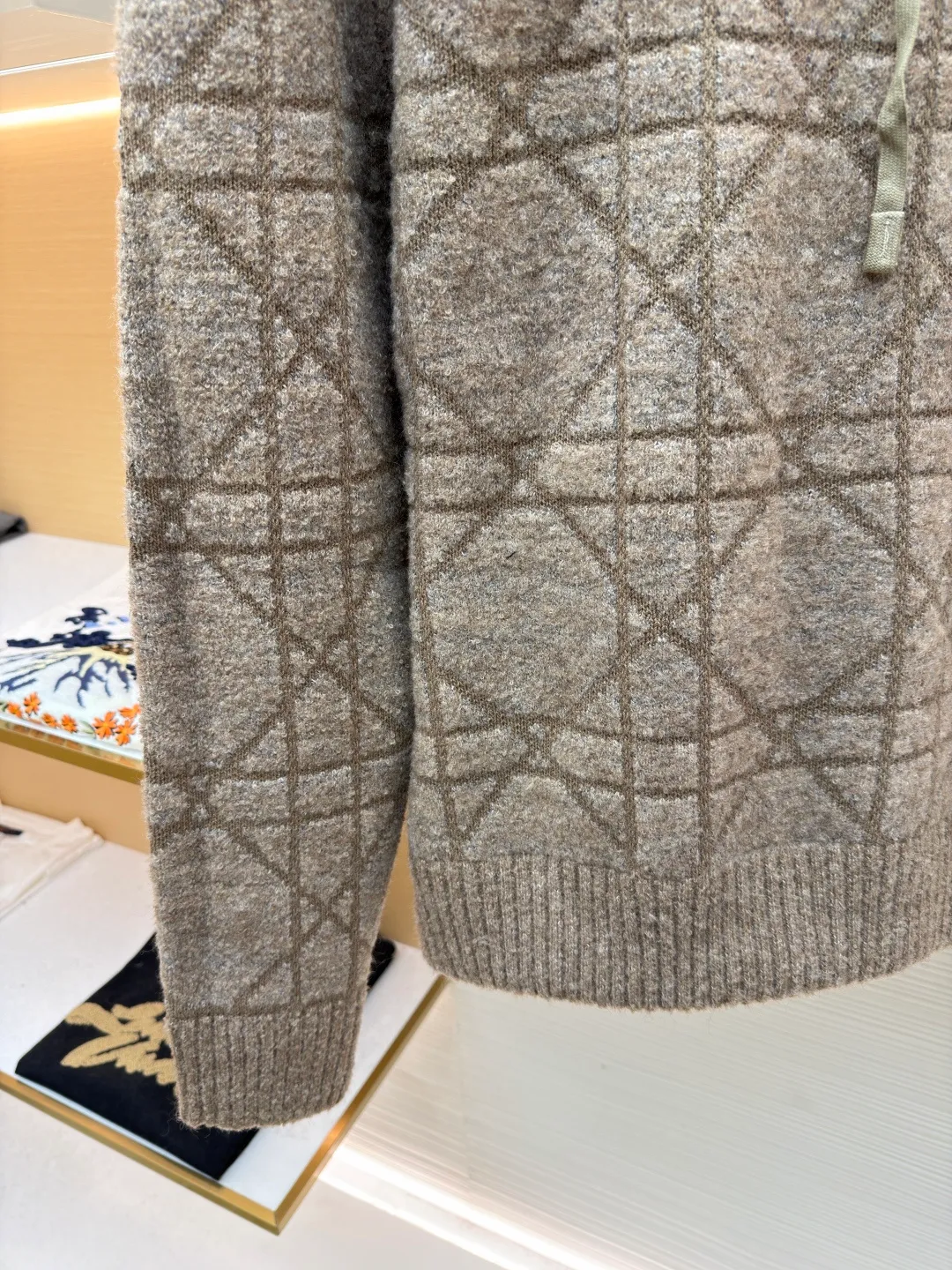 Dior diamond pattern jacquard knitted hoodie ●Original version: purchased and developed in 19726 ●Item number: 1681970-C10 ●Fabric: wool blended fabric ●Technology: jacquard knitting ●Color: camel ●Version: fitted version ●Weight: about 1315 grams ●Size: XS-S-M-L ●Description: This is LV The 2025 autumn and winter series of plush hooded sweaters are made of 100% Albaka wool blend, and the yarn contains 30% alpaca. It is woven with a 16-needle coarse weaving process. The surface presents a matte plush texture and is twice as warm as ordinary wool. The main body of the garment is made of rhombus plaid jacquard, with a three-dimensional texture formed by alternating front and back stitching techniques without additional seams. The hood is made of one-piece knitting, with an invisible shaping lining built into the brim, making it more comfortable to wear. The drawstring is made of core-spun rope of the same material, and the rope ends are treated with metal crimping, making it durable and not easy to wear. The finished product is ironed with low-temperature steam to avoid damage to the plush fibers. The cuffs and hem are ribbed for long-lasting elasticity and a good fit. The whole piece is sewn in an Italian workshop, with no exposed threads in the details, continuing the exquisite standards of the brand's high-end knitted items. The overall stitching is straight and delicate, the fabric is comfortable and soft, and the color is consistent with no color difference. It can be matched with the same style to create a fashionable look and control various occasions. Customized accessories, complete with three standards, the same style for men and women!