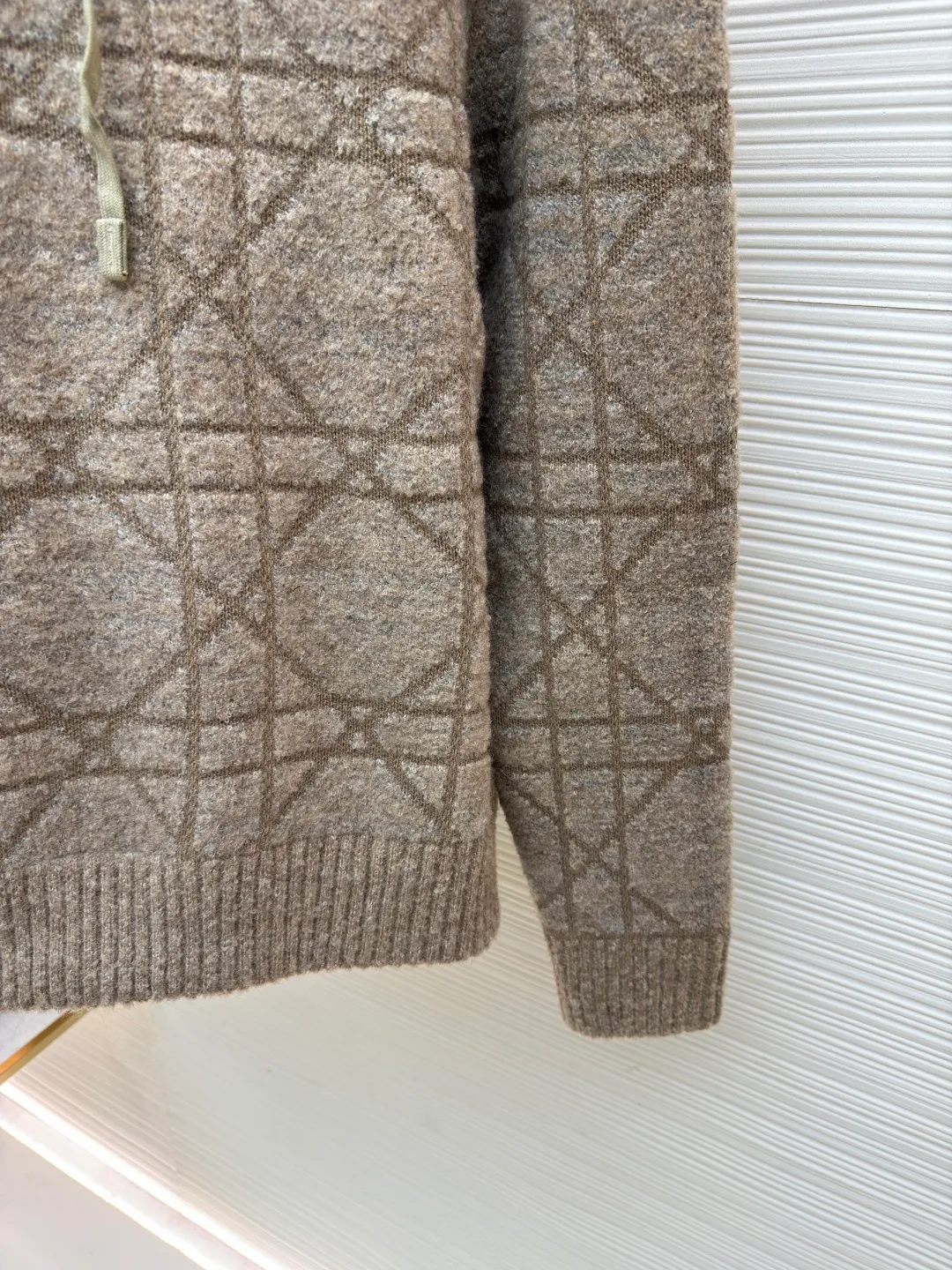 Dior diamond pattern jacquard knitted hoodie ●Original version: purchased and developed in 19726 ●Item number: 1681970-C10 ●Fabric: wool blended fabric ●Technology: jacquard knitting ●Color: camel ●Version: fitted version ●Weight: about 1315 grams ●Size: XS-S-M-L ●Description: This is LV The 2025 autumn and winter series of plush hooded sweaters are made of 100% Albaka wool blend, and the yarn contains 30% alpaca. It is woven with a 16-needle coarse weaving process. The surface presents a matte plush texture and is twice as warm as ordinary wool. The main body of the garment is made of rhombus plaid jacquard, with a three-dimensional texture formed by alternating front and back stitching techniques without additional seams. The hood is made of one-piece knitting, with an invisible shaping lining built into the brim, making it more comfortable to wear. The drawstring is made of core-spun rope of the same material, and the rope ends are treated with metal crimping, making it durable and not easy to wear. The finished product is ironed with low-temperature steam to avoid damage to the plush fibers. The cuffs and hem are ribbed for long-lasting elasticity and a good fit. The whole piece is sewn in an Italian workshop, with no exposed threads in the details, continuing the exquisite standards of the brand's high-end knitted items. The overall stitching is straight and delicate, the fabric is comfortable and soft, and the color is consistent with no color difference. It can be matched with the same style to create a fashionable look and control various occasions. Customized accessories, complete with three standards, the same style for men and women!