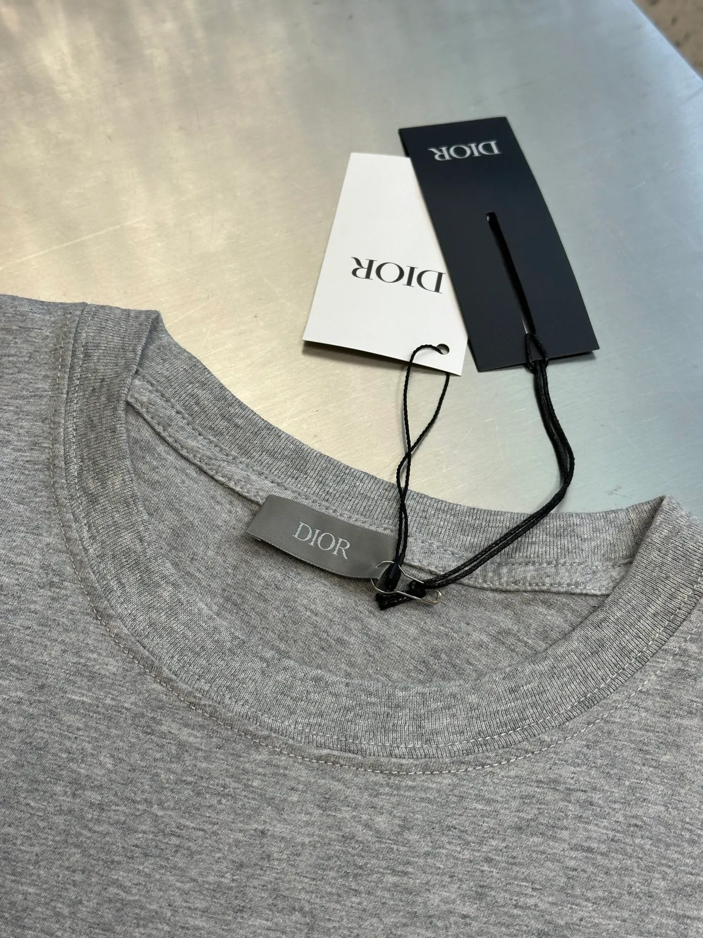 🅿️260 Dior Love Series Pocket Embroidery Round Neck Short Sleeve Cotton Jersey Fabric. Made of 24S special woven compact cotton fabric, 185g; with 32S double yarn thread, 300g. The strength of compact yarn is higher than that of traditional single yarn. The single fibers in compact yarn are closely arranged, which helps to improve the strength of the yarn. The ends of the fibers are all twisted into the yarn, so the yarn is very tight and the yarn has a smooth appearance with less hairiness. Compact spinning yarn has higher strength and less hairiness, making it less prone to fraying.  The chest is decorated with embroidery patterns, and the main body adopts precision stitch embroidery technology; the embroidery is very fine and dense, with clear patterns and strong lines and three-dimensionality. The linen material embroidery thread is combined with encrypted processing, and the embroidery body has a subtle matte visual texture; the embroidery effect is three-dimensional and full. The flat embroidery has a unique needle-to-needle design, and the embroidery is very fine and dense. The overall stitching is fine, with consistent fineness and texture, adding a sense of layering to the simple design.  Standard crew neck, short sleeve fit. The neckline is rounded and arc-shaped, suitable for various face shapes and body shapes; the sleeve length is moderate and ends just above the elbow, showing a smart and neat image. The slim fit can show off the wearer's body curves without sacrificing comfort. The collar, cuffs, hem and other parts are all sewn with fine double-needle stitching.  size：xs s m l
