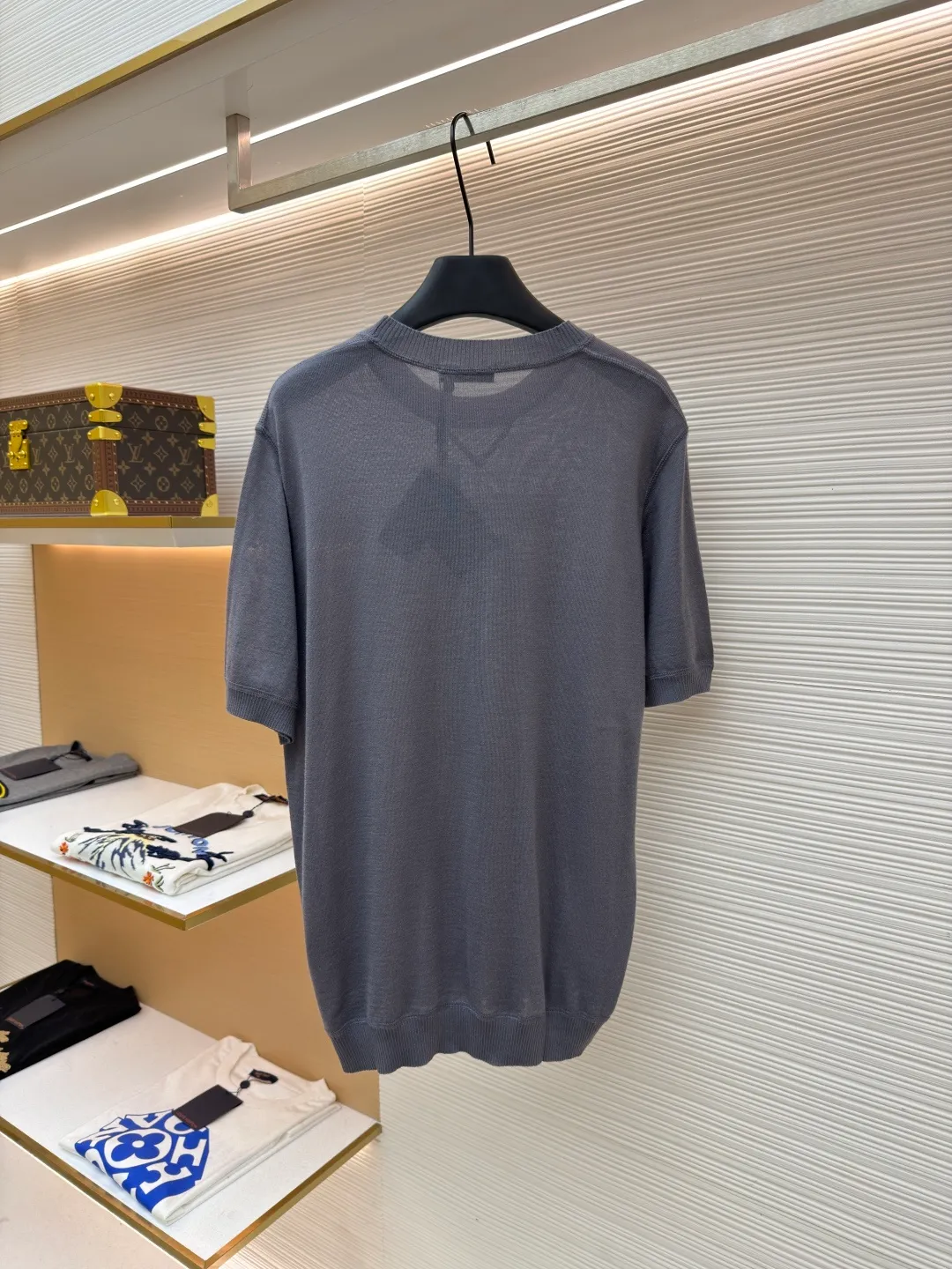 Prada classic LOGO jacquard wool round neck short sleeves ●Original version: purchased and developed by 11988 ●Item number: 1682515-A45 ●Fabric: wool fabric ●Technology: jacquard production ●Color: gray ●Version: fitted version ●Weight: about 150 grams ●Size: 46-48-50-52 ●Description: This PRADA gray knitted short-sleeve is woven with high-quality combed cotton threads. The body is made of vertical pit knitting technology. The texture is three-dimensional and elastic. It is soft and breathable when worn next to the skin. It has good drape and stiffness, and is not prone to pilling and deformation. The brand letters and badge pattern on the front of the garment are made with precision embroidery technology. The embroidery thread is made of imported high-gloss yarn. The stitches are dense and even, and the pattern is three-dimensional and clear. It forms a texture contrast with the knitted base to highlight the brand recognition. The neckline is a classic round neck design, with double-needle reinforced hemming technology and a customized threaded collar, which is durable and not easy to loosen. The cuffs and hem are ribbed in the same color. The overall cut is a loose silhouette. The stitching is straight and fine. The customized accessories and three standards are complete. The detailed craftsmanship shows the level of luxury. It is suitable for casual daily and light business wear scenarios. The overall wiring is straight and delicate, the fabric is comfortable and soft, and the color is consistent without color difference. It can be matched with the same style to create a fashionable look and control various occasions. Customized accessories, complete with three standards, same style for men and women!