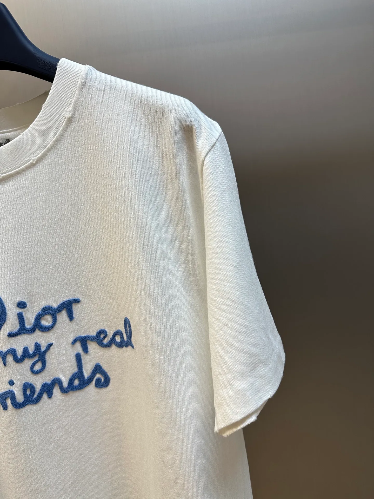 🅿️280 Dior Friends letter embroidered round neck short sleeves are made of pure cotton 12S fine cotton plain weave. The fabric is interwoven with plain weave. The yarns have many buckling points, which makes the fabric have good fastness and wear resistance. The density is moderate, the fabric is thin, flat and stiff. It has good breathability, is softer, more delicate, and has better gloss.  The joint series logo is chain embroidery. Chain embroidery is named because the visual effect of the embroidery is like a chain. The shape is like the links on the chain. It is commonly known as chain embroidery and also called chain eye embroidery. Follow the chain stitch stitch method and embroider from right to left. Maintain the tension of the embroidery thread and the uniformity of the stitches to ensure the three-dimensionality and exquisiteness of the embroidery. It combines the stitching method of chain embroidery with the material of fine wool to create embroidery with chain-like texture and three-dimensional effect.  The whole piece is designed with washed holes and irregular openings all over the body. The simple garments have a rebellious and destructive design. The stone grinding washing process locates the holes, and the ready-to-wear products use the stone grinding machine laser positioning to manually destroy the wear effect. Every wear and tear is made by hand, so that the natural wear and tear of the fabric achieves the most harmonious visual effect. After being washed by stone grinding, it can show a rich retro atmosphere.  The standard round neck and short-sleeved version has a rounded arc neckline, which is suitable for various face shapes and body shapes; the sleeve length is moderate and ends just above the elbow, showing a smart and neat image. The slim fit can show off the wearer's body curves without sacrificing comfort. The collar, cuffs, hem and other parts are all sewn with fine double-needle stitching.  size：xs s m l