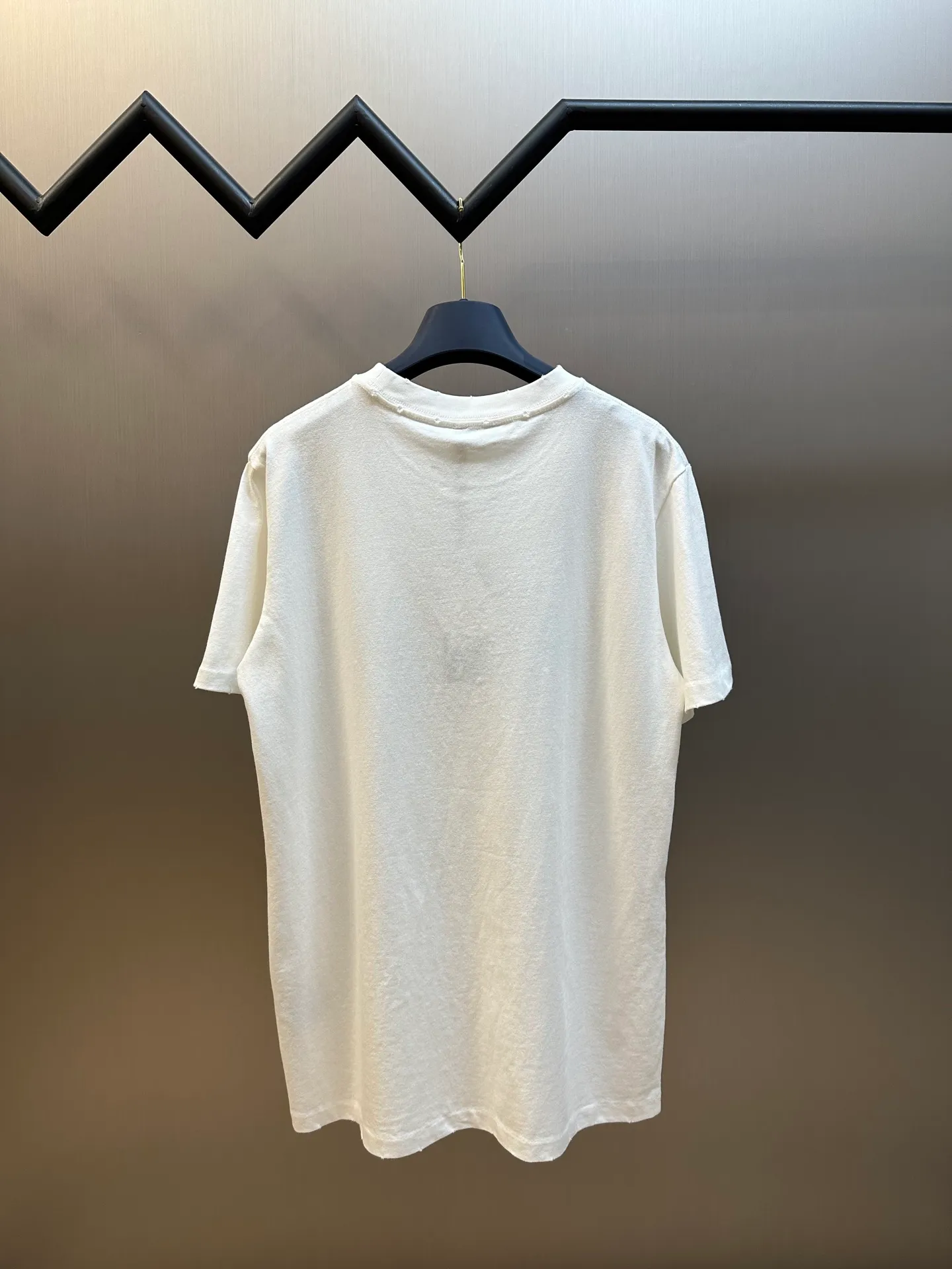 🅿️280 Dior Friends letter embroidered round neck short sleeves are made of pure cotton 12S fine cotton plain weave. The fabric is interwoven with plain weave. The yarns have many buckling points, which makes the fabric have good fastness and wear resistance. The density is moderate, the fabric is thin, flat and stiff. It has good breathability, is softer, more delicate, and has better gloss.  The joint series logo is chain embroidery. Chain embroidery is named because the visual effect of the embroidery is like a chain. The shape is like the links on the chain. It is commonly known as chain embroidery and also called chain eye embroidery. Follow the chain stitch stitch method and embroider from right to left. Maintain the tension of the embroidery thread and the uniformity of the stitches to ensure the three-dimensionality and exquisiteness of the embroidery. It combines the stitching method of chain embroidery with the material of fine wool to create embroidery with chain-like texture and three-dimensional effect.  The whole piece is designed with washed holes and irregular openings all over the body. The simple garments have a rebellious and destructive design. The stone grinding washing process locates the holes, and the ready-to-wear products use the stone grinding machine laser positioning to manually destroy the wear effect. Every wear and tear is made by hand, so that the natural wear and tear of the fabric achieves the most harmonious visual effect. After being washed by stone grinding, it can show a rich retro atmosphere.  The standard round neck and short-sleeved version has a rounded arc neckline, which is suitable for various face shapes and body shapes; the sleeve length is moderate and ends just above the elbow, showing a smart and neat image. The slim fit can show off the wearer's body curves without sacrificing comfort. The collar, cuffs, hem and other parts are all sewn with fine double-needle stitching.  size：xs s m l