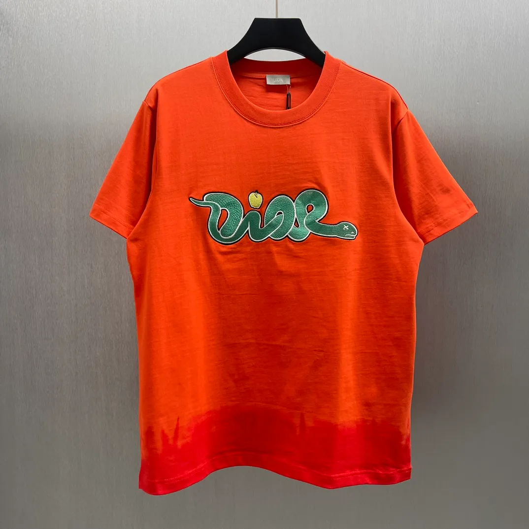 🅿️320 🧧CD 🐍Year Limited Colorful Embroidery🐍Short Sleeve Size: S-L This T-shirt is from the DIOR AND KAWVS limited series. Crafted from orange and red cotton jersey, it features green DIORAND KAWS embroidery on the chest and back, reinterpreting the Dior logo as a colorful snake. The hem highlights the contrasting design and can be paired with the limited collection of trousers for a stylish look.