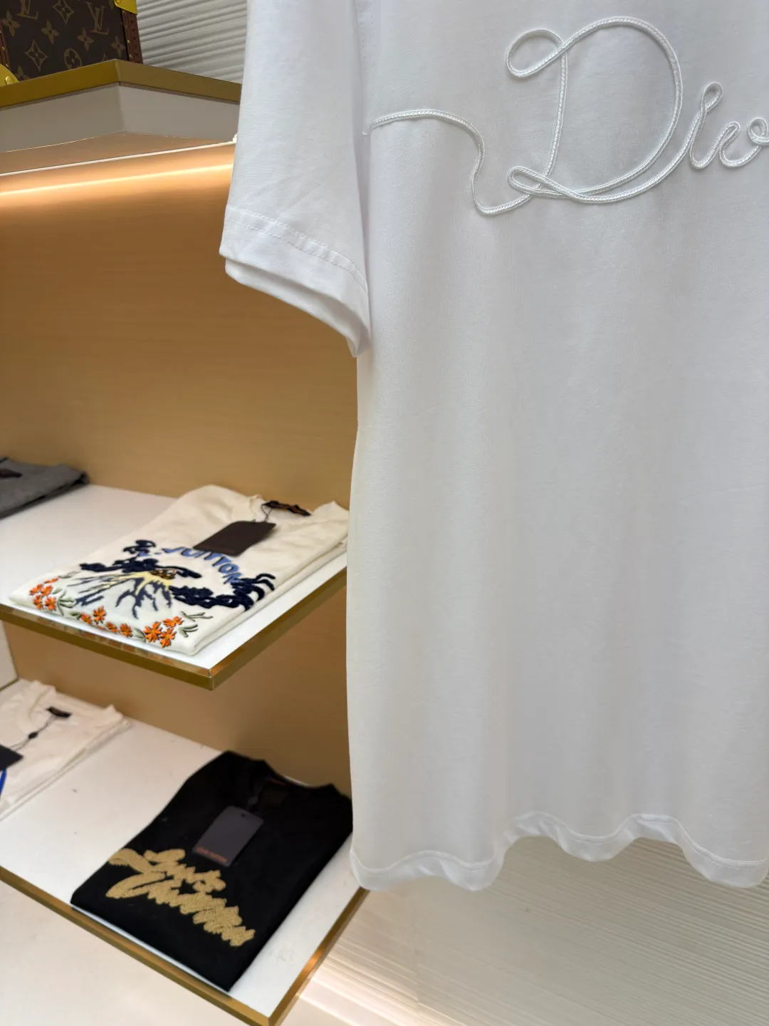 Dior satin emblem round neck short sleeves ●Original version: purchased and developed by 7089 ●Item number: 1681695-A00 ●Fabric: cotton jersey fabric ●Technology: embroidery production ●Color: white ●Version: fitted version ●Weight: about 205 grams ●Size: XS-S-M-L ●Description: The main body is made of 24-count special-spun compact cotton. The weight of 185g/㎡ is light to medium, ensuring the lightness, breathability and good drape of the T-shirt. It is suitable for both spring wear alone and as an inner layer. With 32 pieces of 1×1 rib, 300g/㎡. Its special spinning and compacting process means that compact spinning technology is used in the spinning process, which effectively reduces the hairiness of the yarn, making the yarn smoother and stronger. The woven fabric therefore has the advantages of compact structure, smooth surface, and resistance to pilling. The final dark gray tone is combined with the simple texture of jersey to create a high-end matte texture. Embroidery decoration in the form of satin ribbons, which are fixed on the fabric through special processing. The texture brought by this process is usually different from the woven texture and slight luster of the main knitted fabric. It forms a delicate and accessible visual and tactile focus on the matte dark gray base, enhancing the craftsmanship, design and uniqueness of the single product. The overall wiring is straight and delicate, the fabric is comfortable and soft, and the color is consistent without color difference. It can be matched with the same style to create a fashionable look and control various occasions. Customized accessories, complete with three standards, same style for men and women!