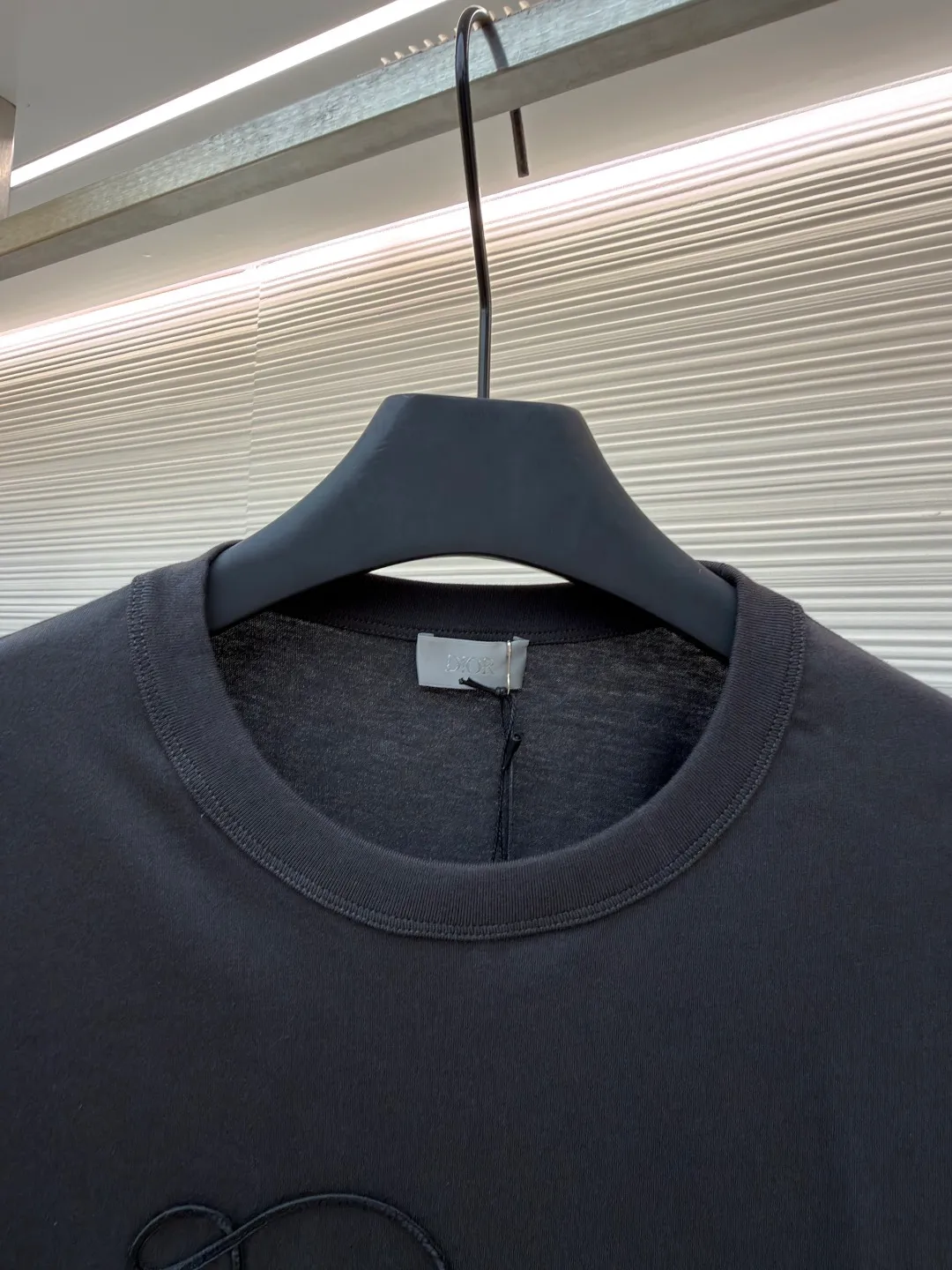 Dior satin emblem round neck short sleeves ●Original version: purchased and developed by 7089 ●Item number: 1681694-A00 ●Fabric: cotton jersey fabric ●Technology: embroidery production ●Color: dark gray ●Version: fitted version ●Weight: about 200 grams ●Size: XS-S-M-L ●Description: The main body is made of 24-count special-spun compact cotton. The weight of 185g/㎡ is light to medium, ensuring the lightness, breathability and good drape of the T-shirt. It is suitable for both spring wear alone and as an inner layer. With 32 pieces of 1×1 rib, 300g/㎡. Its special spinning and compacting process means that compact spinning technology is used in the spinning process, which effectively reduces the hairiness of the yarn, making the yarn smoother and stronger. The woven fabric therefore has the advantages of compact structure, smooth surface, and resistance to pilling. The final dark gray tone is combined with the simple texture of jersey to create a high-end matte texture. Embroidery decoration in the form of satin ribbons, which are fixed on the fabric through special processing. The texture brought by this process is usually different from the woven texture and slight luster of the main knitted fabric. It forms a delicate and accessible visual and tactile focus on the matte dark gray base, enhancing the craftsmanship, design and uniqueness of the single product. The overall wiring is straight and delicate, the fabric is comfortable and soft, and the color is consistent without color difference. It can be matched with the same style to create a fashionable look and control various occasions. Customized accessories, complete with three standards, same style for men and women!