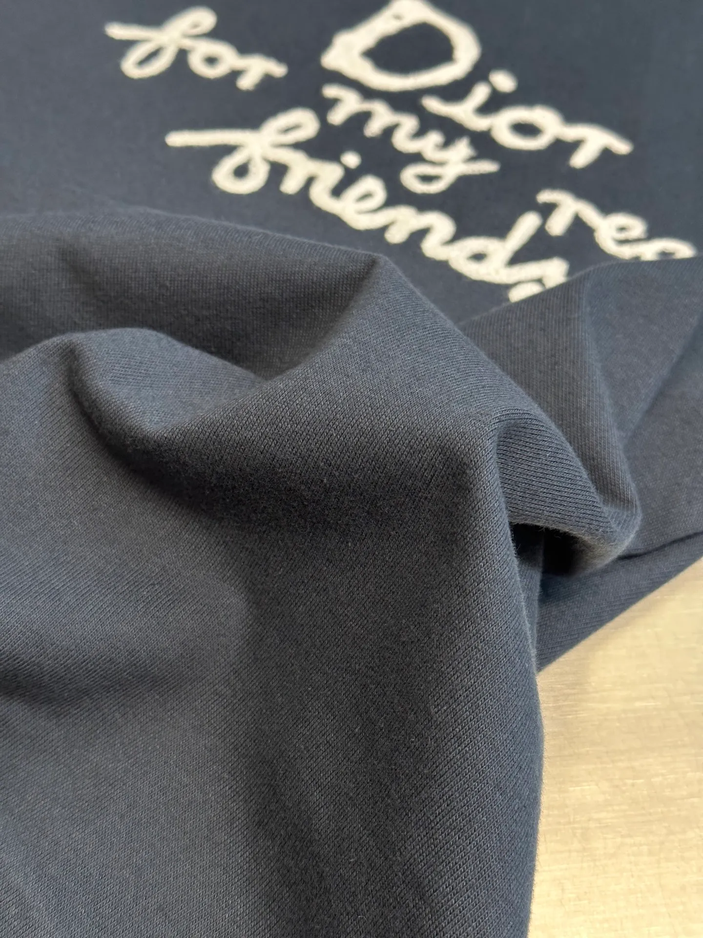 🅿️280 Dior Friends letter embroidered round neck short sleeves are made of pure cotton 12S fine cotton plain weave. The fabric is interwoven with plain weave. The yarns have many buckling points, which makes the fabric have good fastness and wear resistance. The density is moderate, the fabric is thin, flat and stiff. It has good breathability, is softer, more delicate, and has better gloss.  The joint series logo is chain embroidery. Chain embroidery is named because the visual effect of the embroidery is like a chain. The shape is like the links on the chain. It is commonly known as chain embroidery and also called chain eye embroidery. Follow the chain stitch stitch method and embroider from right to left. Maintain the tension of the embroidery thread and the uniformity of the stitches to ensure the three-dimensionality and exquisiteness of the embroidery. It combines the stitching method of chain embroidery with the material of fine wool to create embroidery with chain-like texture and three-dimensional effect.  The whole piece is designed with washed holes and irregular openings all over the body. The simple garments have a rebellious and destructive design. The stone grinding washing process locates the holes, and the ready-to-wear products use the stone grinding machine laser positioning to manually destroy the wear effect. Every wear and tear is made by hand, so that the natural wear and tear of the fabric achieves the most harmonious visual effect. After being washed by stone grinding, it can show a rich retro atmosphere.  The standard round neck and short-sleeved version has a rounded arc neckline, which is suitable for various face shapes and body shapes; the sleeve length is moderate and ends just above the elbow, showing a smart and neat image. The slim fit can show off the wearer's body curves without sacrificing comfort. The collar, cuffs, hem and other parts are all sewn with fine double-needle stitching.  size：xs s m l