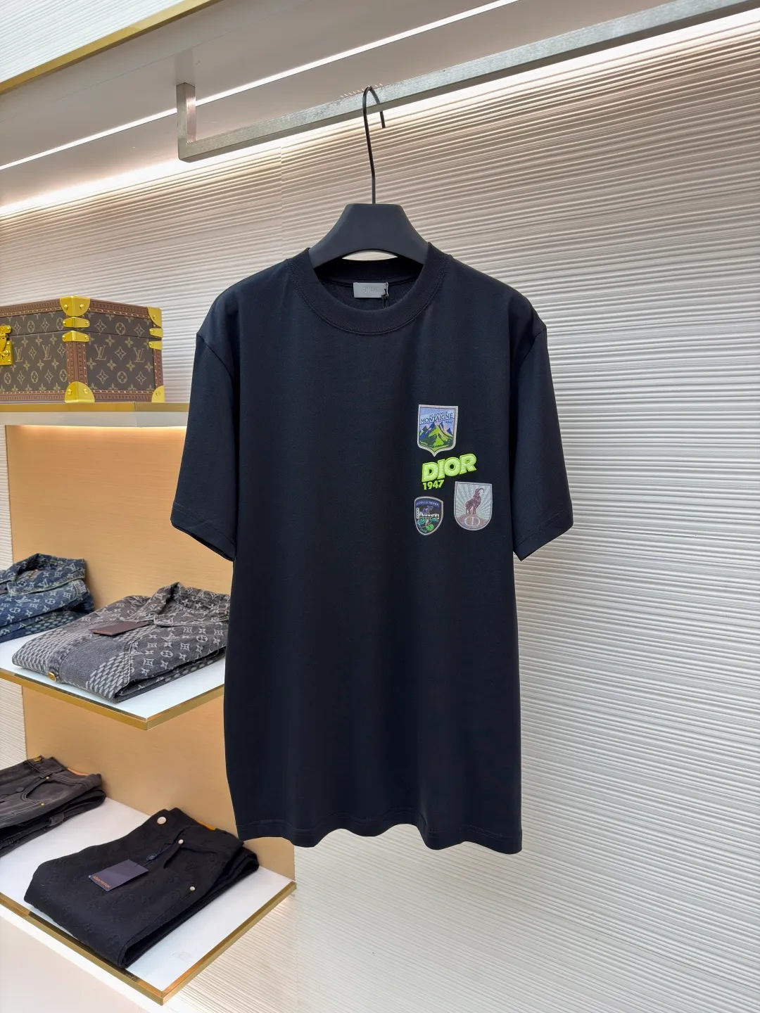 Dior Alpine Embroidery Round Neck Short Sleeve ●Original version: Purchased and developed by 7149 ●Item number: 1681101-X95 ●Fabric: plain knitted fabric ●Technology: white ink direct injection production ●Version: fitted version ●Weight: about 215 grams ●Size: S-M-L-XL ●Description: The main body is made of 24S special woven compact cotton to make plain knitted fabric, weight 180g. High-count combed cotton yarn eliminates most of the short hairiness through compact spinning process, making the yarn smoother and stronger. The woven fabric structure is extremely dense, flat and soft, with excellent anti-pilling ability and durability, while retaining the natural advantages of pure cotton, which is breathable and skin-friendly. The neckline is made of 32S 1x1 rib with a weight of 300g. The finer yarn count creates a more delicate and tight thread, which provides better elasticity and deformation resistance than ordinary ribs, ensuring that the neckline can still remain stiff after being put on and taken off many times. The printed pattern and classic logo inspired by the mountain spirit on the chest become the visual focus through the decoration combined with multiple techniques. The printed pattern elements use digital white ink direct injection technology, which presents bright, opaque white and color patterns on dark fabrics with clear edges and a smooth touch. The classic logo is completed with fluorescent green contrasting letters in the form of patches, which are then precisely sewn onto the fabric using appliqué technology. This process restores the three-dimensionality, color saturation and detail accuracy of the pattern to the original version. With the standard round neck shape and basic color, this product has established a high degree of matching tolerance. It can be mixed and matched with daily jeans or shorts, catering to the pursuit of functionality, comfort and details. The neckline has a rounded arc, suitable for various face shapes and body shapes; the sleeves are moderate and end just above the elbow, showing a smart and neat image. The slim-fitting cut shows off the wearer's body curves without sacrificing comfort. The collar, cuffs, hem and other parts are all sewn with fine double-needle stitching. The overall wiring is straight and delicate, the fabric is comfortable and soft, and the color is consistent without color difference. It can be matched with the same style to create a fashionable look and control various occasions. Customized accessories, complete with three standards, same style for men and women!