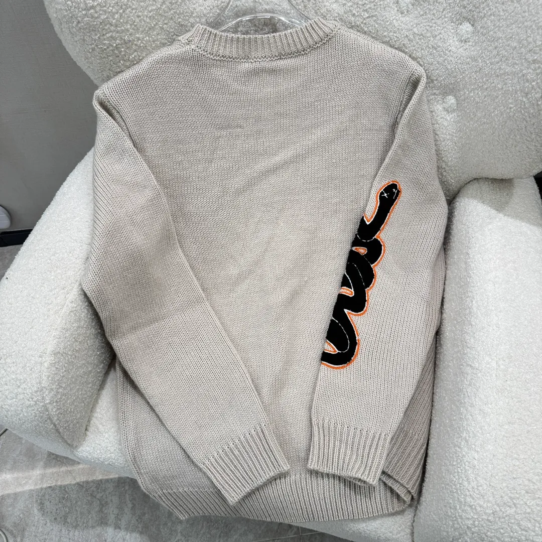🅿️380 DIOR CD Sheep Wool Blended Jersey Sweater This sweater is a new product of the 2024 Spring and Summer Men's Wear Series. It comes from the AND OTANIWORKSHOP joint series. The sleeves display brand embroidery. The sleeves are embroidered with snake pattern design. Carefully made with wool blended jersey fabric. Round neck design presents a fashionable burnt effect style. It can be matched with all kinds of casual clothing to create a classic look. The patch pattern is a combination of stitch embroidery and needle embroidery. The theme pattern uses needle embroidery, using finer wool. The pattern is formed by inserting stitches, which has a unique texture and artistic effect. The cuff wool embroidery thread is inserted into the needle embroidery process. The needles are interwoven with needles of different lengths to achieve an uneven effect. The embroidery surface is specially treated, and wool is used to embroider the embroidery. Its fineness makes the silk thread smooth and smooth. Then the flat embroidery stitch is used to finish the overall embroidery pattern. The body is designed with irregular holes. It has a casual and uninhibited design and feels fluffy. It has high resilience and is not restrictive. When washing, the focus is on creating the velvety texture of cashmere itself. It is soft to the touch, not sticky, and does not stick to the body.