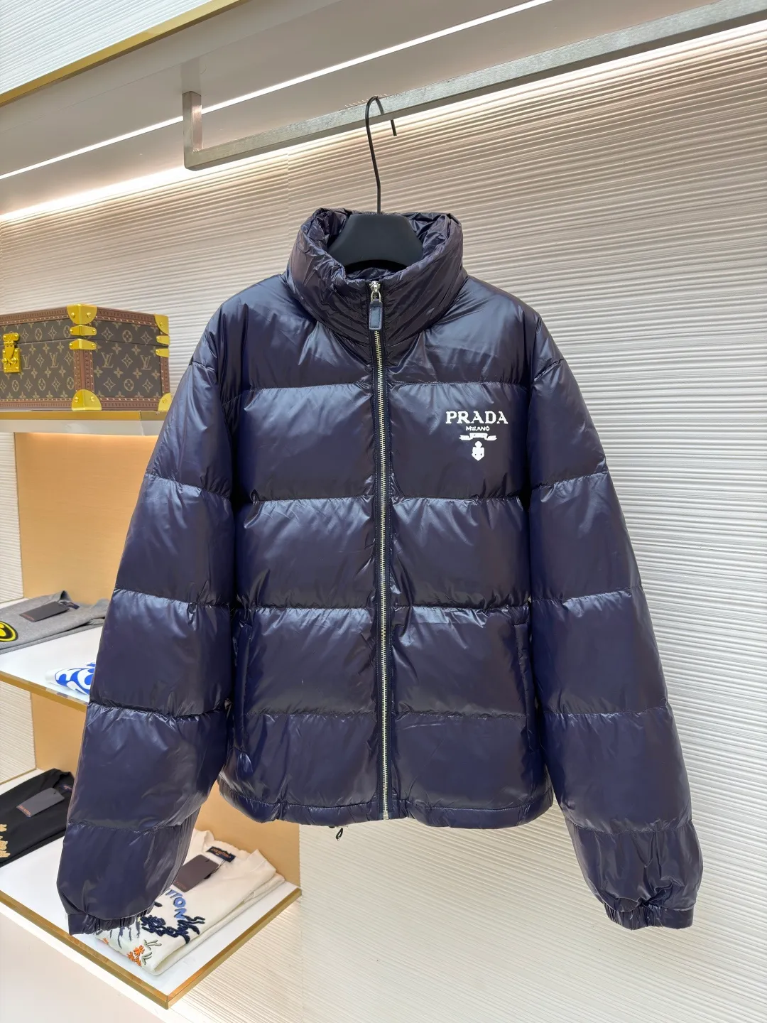 Prada Solid Color Logo Printed Quilted Stand Collar Jacket ●Original version: Purchased and developed for 8999 ●Item number: 1682008-E20 ●Fabric: white duck down fabric ●Technology: mechanical down filling ●Color: blue-purple ●Version: fitted version ●Weight: about 755 grams ●Size: S-M-L-XL ●Description: The fabric is made of high-gloss nylon, with a water-repellent treatment on the surface, making it smooth to the touch and protective. The interior is filled with high-fill down, and is divided into a full plaid pattern through even quilting to ensure warmth while avoiding accumulation of down. The neckline is a stand-up collar design, with a hidden metal zipper, and the zipper track is hemmed to make opening and closing smoother. The "PRADA" logo and brand logo on the left chest are made of precision offset printing technology, and the color is firm and not easy to fall off. The cuffs and hem are edged with elastic ribs, which fit the body shape and are highly windproof. The overall stitching is fine and neat, and the edges are overlocked in the same color, taking into account modern texture and high-end craftsmanship standards. The overall wiring is straight and delicate, the fabric is comfortable and soft, and the color is consistent without color difference. It can be matched with the same style to create a fashionable look and control various occasions. Customized accessories, complete with three standards, same style for men and women!