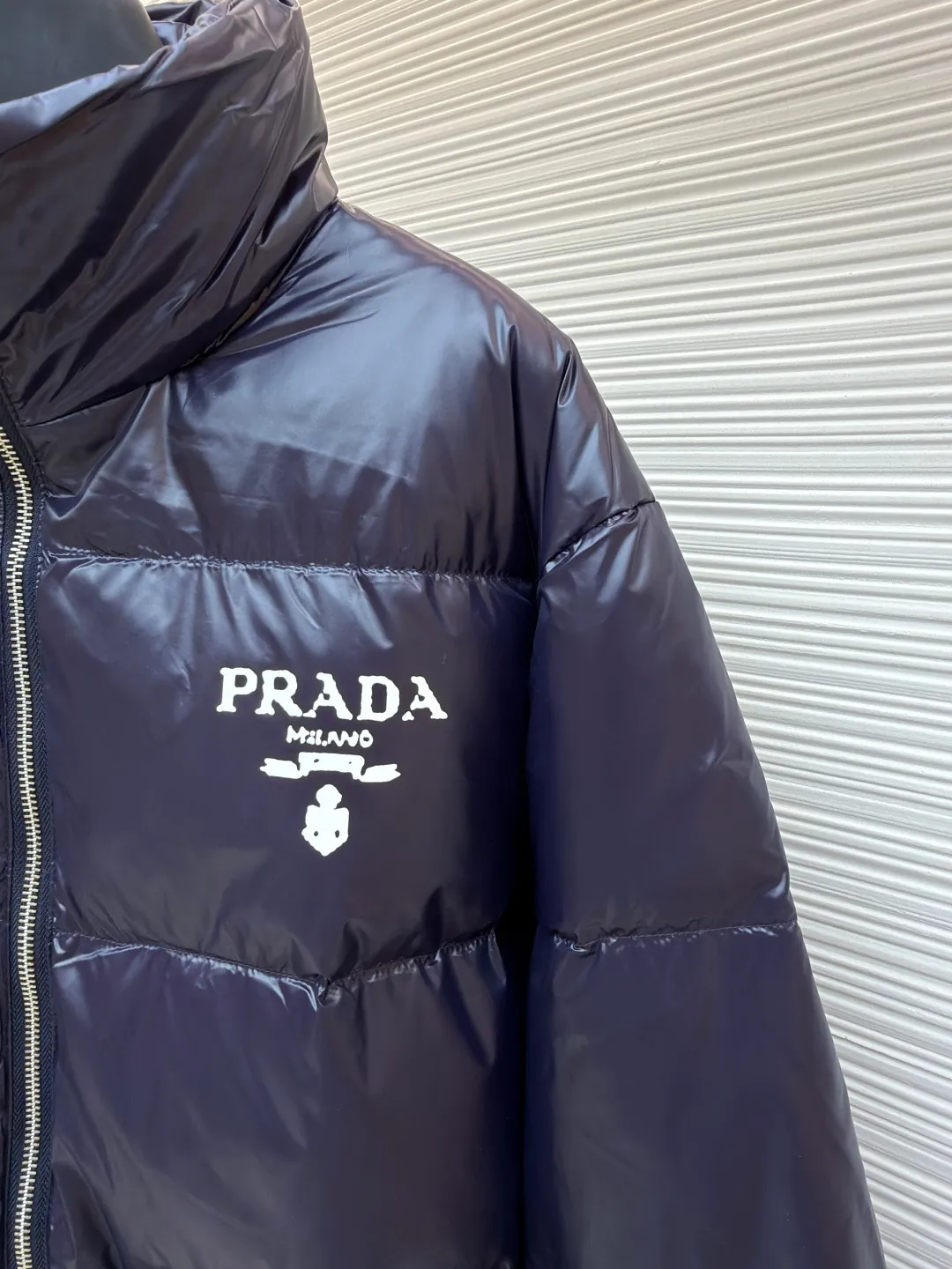 Prada Solid Color Logo Printed Quilted Stand Collar Jacket ●Original version: Purchased and developed for 8999 ●Item number: 1682008-E20 ●Fabric: white duck down fabric ●Technology: mechanical down filling ●Color: blue-purple ●Version: fitted version ●Weight: about 755 grams ●Size: S-M-L-XL ●Description: The fabric is made of high-gloss nylon, with a water-repellent treatment on the surface, making it smooth to the touch and protective. The interior is filled with high-fill down, and is divided into a full plaid pattern through even quilting to ensure warmth while avoiding accumulation of down. The neckline is a stand-up collar design, with a hidden metal zipper, and the zipper track is hemmed to make opening and closing smoother. The "PRADA" logo and brand logo on the left chest are made of precision offset printing technology, and the color is firm and not easy to fall off. The cuffs and hem are edged with elastic ribs, which fit the body shape and are highly windproof. The overall stitching is fine and neat, and the edges are overlocked in the same color, taking into account modern texture and high-end craftsmanship standards. The overall wiring is straight and delicate, the fabric is comfortable and soft, and the color is consistent without color difference. It can be matched with the same style to create a fashionable look and control various occasions. Customized accessories, complete with three standards, same style for men and women!