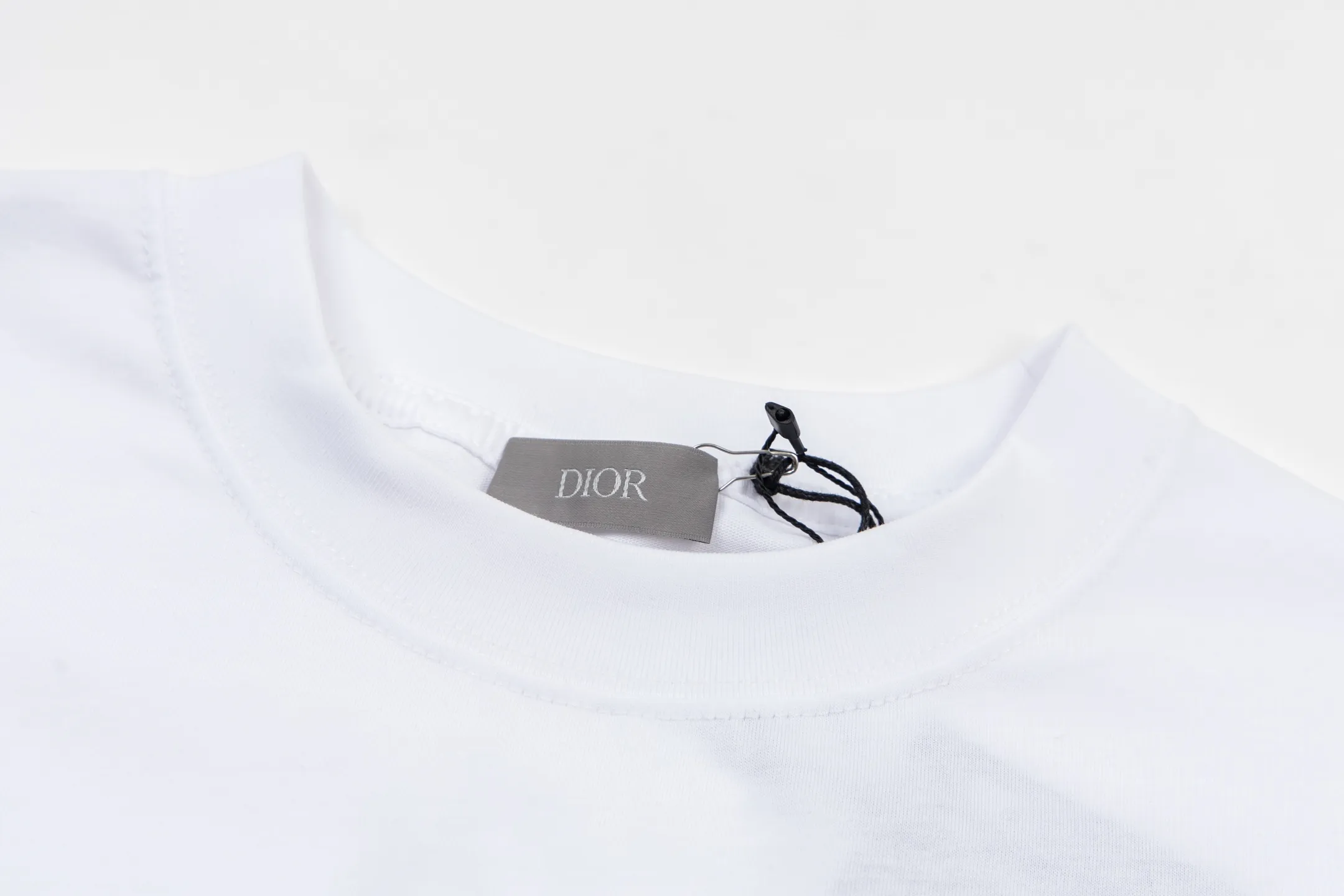 🅿️270 CD AND DESCENT Reflective Printed Short Sleeve (White) The fabric is made of 24S 185g special woven compact cotton fabric, and the rib is made of 32S 300g double yarn rib. This T-shirt is a new product in the 2026 spring men's wear series, inspired by performance sportswear. Crafted from white cotton jersey with reflective ANDDESCENTE pattern. The ribbed round neck design can be layered with a zippered sweatshirt to create a sophisticated sporty look. The fabric is made of 24S special-spun compact cotton as a plain knitted base. The high-count compact spinning process ensures that the fabric has an extremely delicate skin feel and excellent anti-pilling durability. The neckline is equipped with 32S 1x1 high-density ribbing, which provides long-lasting rebound with its tight structure and protects the collar shape. It uses an advanced laser cutting reflective engraving film thermal transfer process: first, the composite reflective film with built-in micro glass beads is carved out by a high-precision laser cutting machine to create the precise outline of the words; the imprint is positioned and imprinted through precisely controlled temperature, pressure and time. It ensures the sharp and clear edges of the pattern and gives the item unique dynamic visual attributes. Under daily light, it presents a low-key silver-gray color, but when exposed to light in a dark place, it instantly bursts out with strong retroreflection. Through innovative reflective technology and sophisticated basic materials, performance is transformed into a perceptible visual language. Size:XS-S-M-L