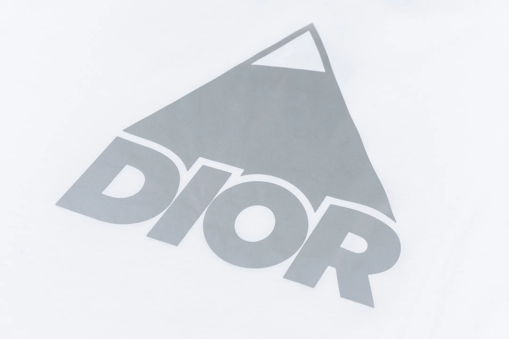 🅿️270 CD AND DESCENT Reflective Printed Short Sleeve (White) The fabric is made of 24S 185g special woven compact cotton fabric, and the rib is made of 32S 300g double yarn rib. This T-shirt is a new product in the 2026 spring men's wear series, inspired by performance sportswear. Crafted from white cotton jersey with reflective ANDDESCENTE pattern. The ribbed round neck design can be layered with a zippered sweatshirt to create a sophisticated sporty look. The fabric is made of 24S special-spun compact cotton as a plain knitted base. The high-count compact spinning process ensures that the fabric has an extremely delicate skin feel and excellent anti-pilling durability. The neckline is equipped with 32S 1x1 high-density ribbing, which provides long-lasting rebound with its tight structure and protects the collar shape. It uses an advanced laser cutting reflective engraving film thermal transfer process: first, the composite reflective film with built-in micro glass beads is carved out by a high-precision laser cutting machine to create the precise outline of the words; the imprint is positioned and imprinted through precisely controlled temperature, pressure and time. It ensures the sharp and clear edges of the pattern and gives the item unique dynamic visual attributes. Under daily light, it presents a low-key silver-gray color, but when exposed to light in a dark place, it instantly bursts out with strong retroreflection. Through innovative reflective technology and sophisticated basic materials, performance is transformed into a perceptible visual language. Size:XS-S-M-L