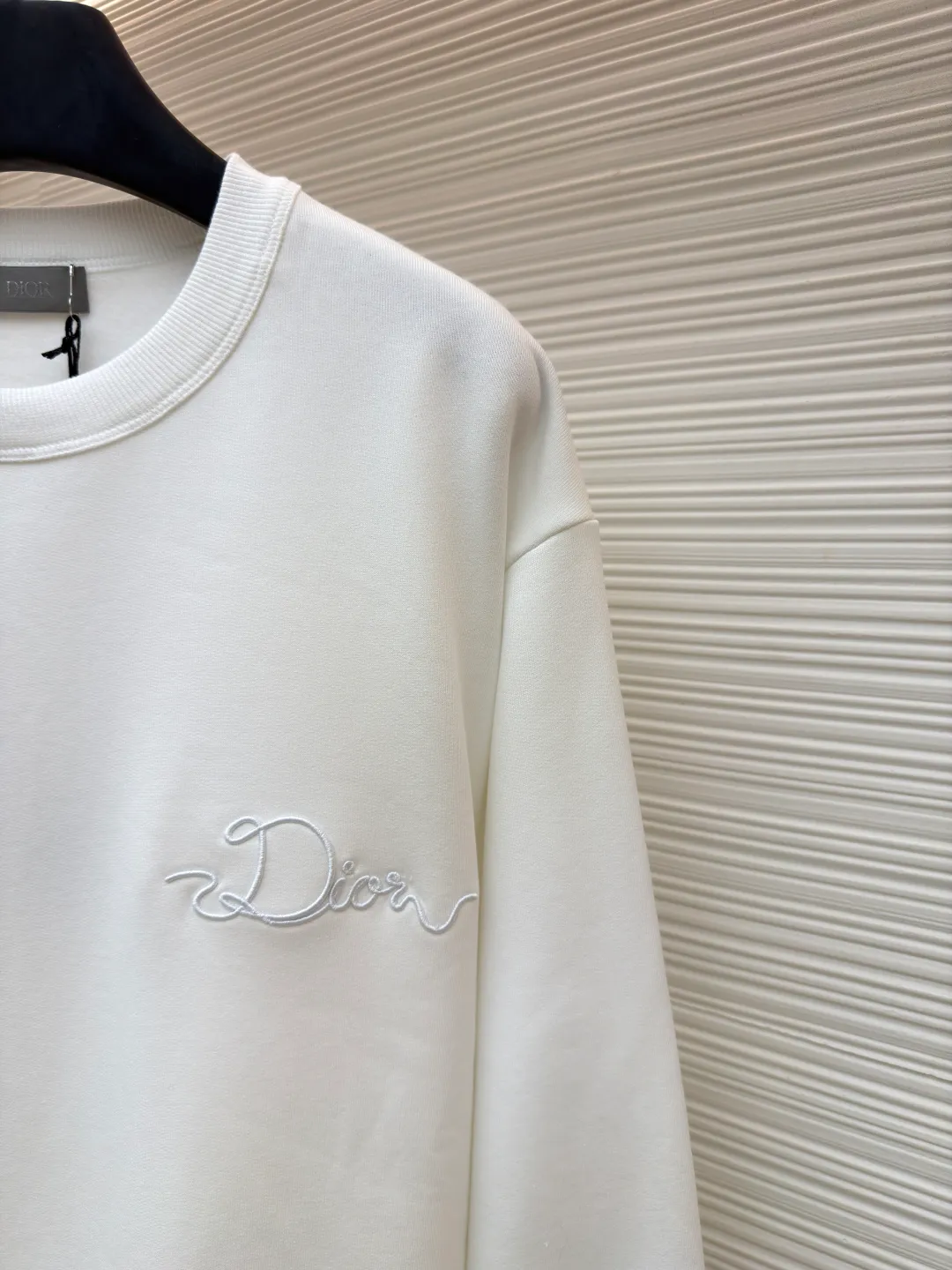 Dior woven satin badge crew neck sweatshirt ●Original version: Purchased and developed by 9976 ●Item number: 1681701-A60 ●Fabric: cotton fleece terry fabric ●Technology: embroidery production ●Color: white ●Version: fitted version ●Weight: about 575 grams ●Size: XS-S-M-L ●Description: The pure cotton texture fabric is made of 26-count double yarn + 10-count base yarn terry fabric, with a weight of 380g/㎡; it is matched with 21-count 2x2 rib, and the composition is 95% cotton and 5% spandex; the weight is 380g/㎡. The 26-count double yarn is used as the surface yarn, and the yarn is thinner, ensuring the delicate and smooth appearance of the fabric and good color fastness; while the 10-count bottom yarn is used as the terry yarn, and the yarn is thicker, forming loose loops during weaving. After unified raising or brushing treatment in the later stage, a layer of rich, dense and soft velvet is formed on the inside of the fabric. The high weight gives the sweatshirt a heavy drape and crisp texture, making it less prone to wrinkles and with stronger styling capabilities. The pure cotton material ensures excellent breathability, moisture absorption and skin-friendly feel, and the final white color appears pure and rich in texture. The overall wiring is straight and delicate, the fabric is comfortable and soft, and the color is consistent without color difference. It can be matched with the same style to create a fashionable look and control various occasions. Customized accessories, complete with three standards, same style for men and women!