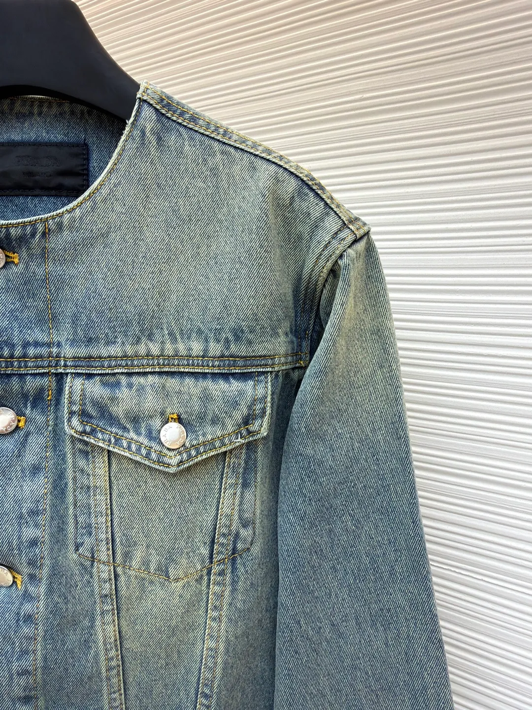 Prada washed denim jacket ●Original version: purchased and developed by 7659 ●Item number: 1680931-B70 ●Material: denim fabric ●Technology: washed production ●Version: fitted version ●Weight: about 855 grams ●Size: S-M-L-XL ●Description: The fabric is made of 100% pure cotton custom-dyed twill 10*10 denim fabric. It has been treated with fine artificial twill and garment washing and fading processes to show a natural distressed effect. The jacket has a fitted fit and an unlined construction for comfort. Round neckline and long sleeves with button closures. The front is opened and closed with a single row of buttons, equipped with a customized triangular steel label and four-button buckle, and the details highlight the brand texture. Contrasting color topstitching and patch pocket design add a sense of hierarchy, and the pocket is equipped with a button flap. The overall design is loosely cut and processed with a special washing process. The fabric is soft and rich in texture. The customized leather label and trademark are perfectly original details, and the collarless design is more casual and fashionable. The overall wiring is straight and delicate, the fabric is comfortable and soft, and the color is consistent without color difference. It can be matched with the same style to create a fashionable look and control various occasions. Customized accessories, complete with three standards, same style for men and women!