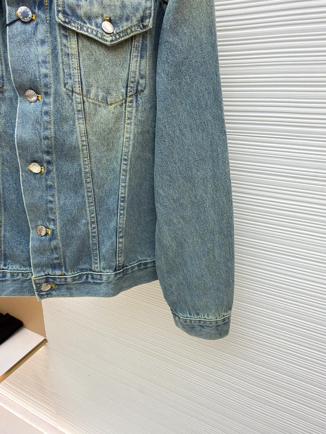 Prada washed denim jacket ●Original version: purchased and developed by 7659 ●Item number: 1680931-B70 ●Material: denim fabric ●Technology: washed production ●Version: fitted version ●Weight: about 855 grams ●Size: S-M-L-XL ●Description: The fabric is made of 100% pure cotton custom-dyed twill 10*10 denim fabric. It has been treated with fine artificial twill and garment washing and fading processes to show a natural distressed effect. The jacket has a fitted fit and an unlined construction for comfort. Round neckline and long sleeves with button closures. The front is opened and closed with a single row of buttons, equipped with a customized triangular steel label and four-button buckle, and the details highlight the brand texture. Contrasting color topstitching and patch pocket design add a sense of hierarchy, and the pocket is equipped with a button flap. The overall design is loosely cut and processed with a special washing process. The fabric is soft and rich in texture. The customized leather label and trademark are perfectly original details, and the collarless design is more casual and fashionable. The overall wiring is straight and delicate, the fabric is comfortable and soft, and the color is consistent without color difference. It can be matched with the same style to create a fashionable look and control various occasions. Customized accessories, complete with three standards, same style for men and women!