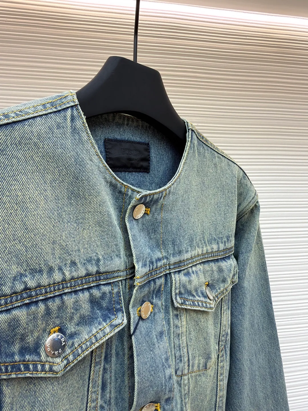 Prada washed denim jacket ●Original version: purchased and developed by 7659 ●Item number: 1680931-B70 ●Material: denim fabric ●Technology: washed production ●Version: fitted version ●Weight: about 855 grams ●Size: S-M-L-XL ●Description: The fabric is made of 100% pure cotton custom-dyed twill 10*10 denim fabric. It has been treated with fine artificial twill and garment washing and fading processes to show a natural distressed effect. The jacket has a fitted fit and an unlined construction for comfort. Round neckline and long sleeves with button closures. The front is opened and closed with a single row of buttons, equipped with a customized triangular steel label and four-button buckle, and the details highlight the brand texture. Contrasting color topstitching and patch pocket design add a sense of hierarchy, and the pocket is equipped with a button flap. The overall design is loosely cut and processed with a special washing process. The fabric is soft and rich in texture. The customized leather label and trademark are perfectly original details, and the collarless design is more casual and fashionable. The overall wiring is straight and delicate, the fabric is comfortable and soft, and the color is consistent without color difference. It can be matched with the same style to create a fashionable look and control various occasions. Customized accessories, complete with three standards, same style for men and women!