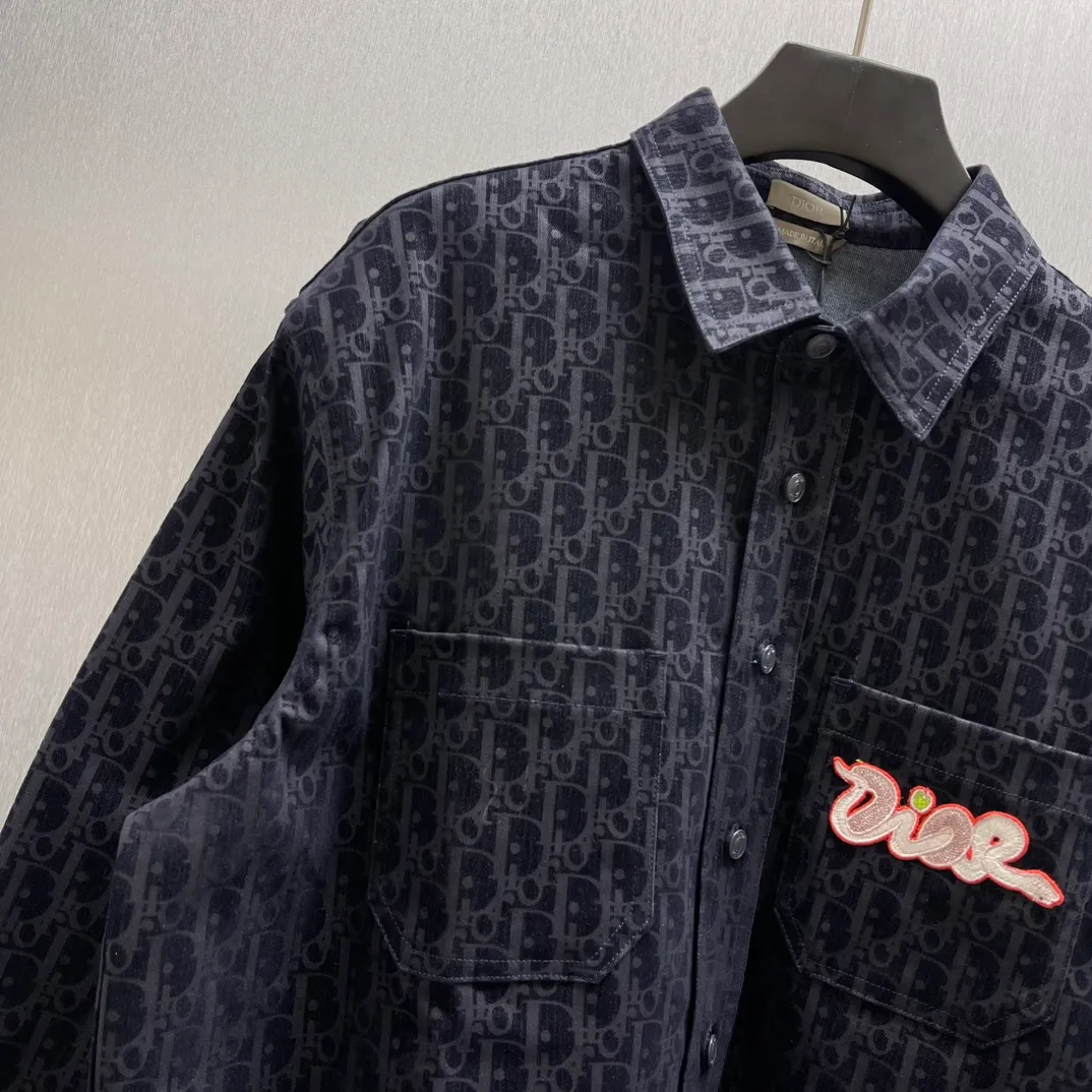 🅿️630 🧧CD blue cotton blended denim fabric jacket shirt SIZE: S-XL This jacket shirt is from the DIOR AND KAWS limited series. Crafted from blue cotton-blend denim, it features the classic Oblique print throughout, complemented by green DIOR AND KAWS embroidery, which reinterprets the Dior logo in a colorful snake shape. Featuring two chest patch pockets, it can be paired with jeans or shorts for a casual yet stylish look.