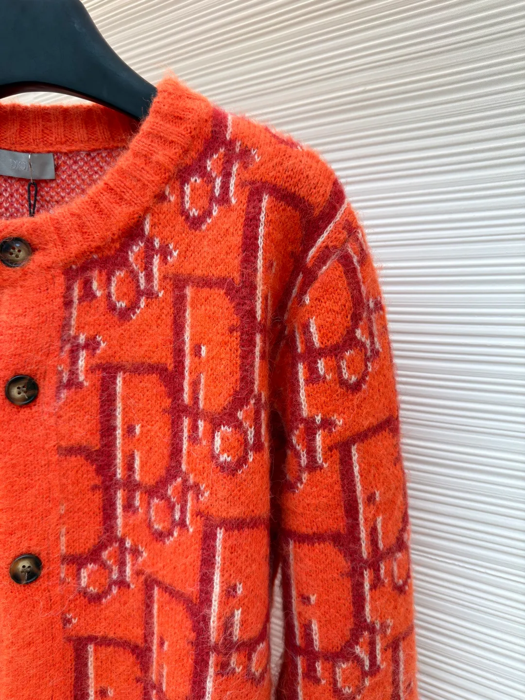 Dior mohair knitted cardigan ●Original version: 21000 purchased and developed ●Item number: 1681335-B60 ●Fabric: mohair fabric ●Technology: knitted ●Color: orange ●Version: fitted version ●Weight: about 725 grams ●Size: S-M-L-XL ●Description: This cardigan is made of mohair blended fabric, which is soft to the touch and has a fluffy texture. The brand's classic letter jacquard is displayed all over the body, which is realized through two-color knitting technology. The pattern texture is clear and three-dimensional, and the colors are distinct. The round neck design is processed by ribbing edge processing, and the neckline is stiff and not easy to deform; the placket is equipped with retro metal buttons, the color is old and echoes the overall style. The ribs on the cuffs and hem are made of high-elastic knitting technology to ensure good fit and resilience. The overall cut is a loose fit, and the splicing of the body uses seamless weaving technology to avoid exposed threads and improve wearing comfort. From jacquard craftsmanship to detail processing, every step reflects the exquisite control of luxury knitwear. It is a fusion of the brand's classic elements and high-end knitting craftsmanship. The overall wiring is straight and delicate, the fabric is comfortable and soft, and the color is consistent without color difference. It can be matched with the same style to create a fashionable look and control various occasions. Customized accessories, complete with three standards, same style for men and women!
