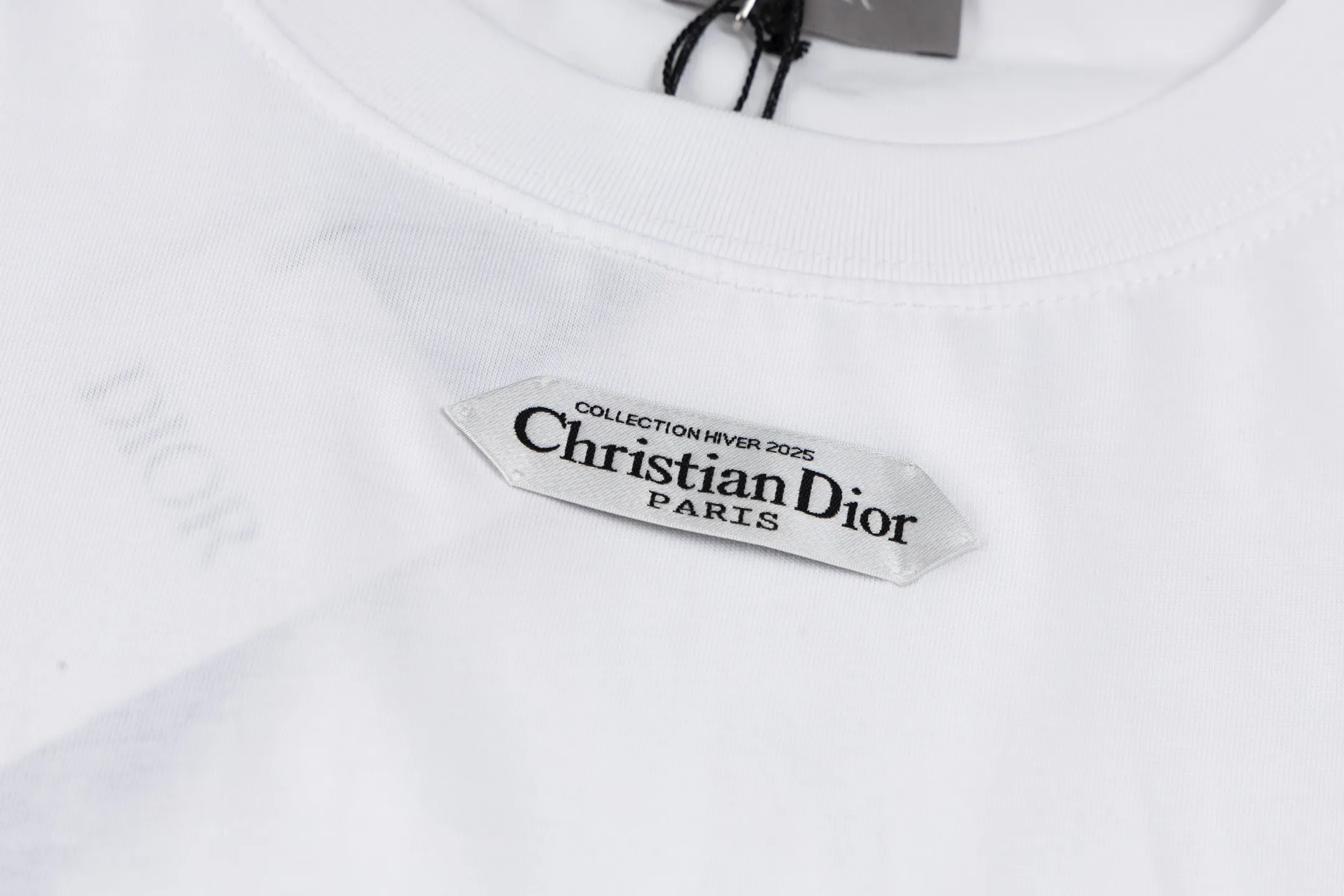 🅿️280 [Exclusive supply] CD 25FW simple label short sleeves (white) The fabric is made of 24S 185g special woven compact cotton fabric, and the rib is made of 32S 300g double yarn rib. This T-shirt is new to the 2025 winter men's collection. It is decorated with a CD Paris logo label inspired by the spirit of haute couture to enhance the style and pay tribute to the extraordinary craftsmanship of the workshop. Crafted from black cotton jersey with a ribbed crew neck and cuffs, it can be worn with track pants for a casual look. It is woven with 24-count special compact cotton yarn. The weaving process requires high standards and requires the use of advanced looms and high-quality raw materials. Specially woven compact cotton has many advantages, such as softness and comfort, good breathability, strong wrinkle resistance, good durability, etc.; it has a tighter, softer and more delicate texture and feel. The brand label on the chest is embellished as the brand's signature detail and is woven using double-sided jacquard technology; black threads are embedded in the white base, or micro-letters are formed through the density of the yarn. The edge of the label is processed by laser cutting, and there are no defects such as yarn leakage and yarn leakage. Size:XS/S/M/L