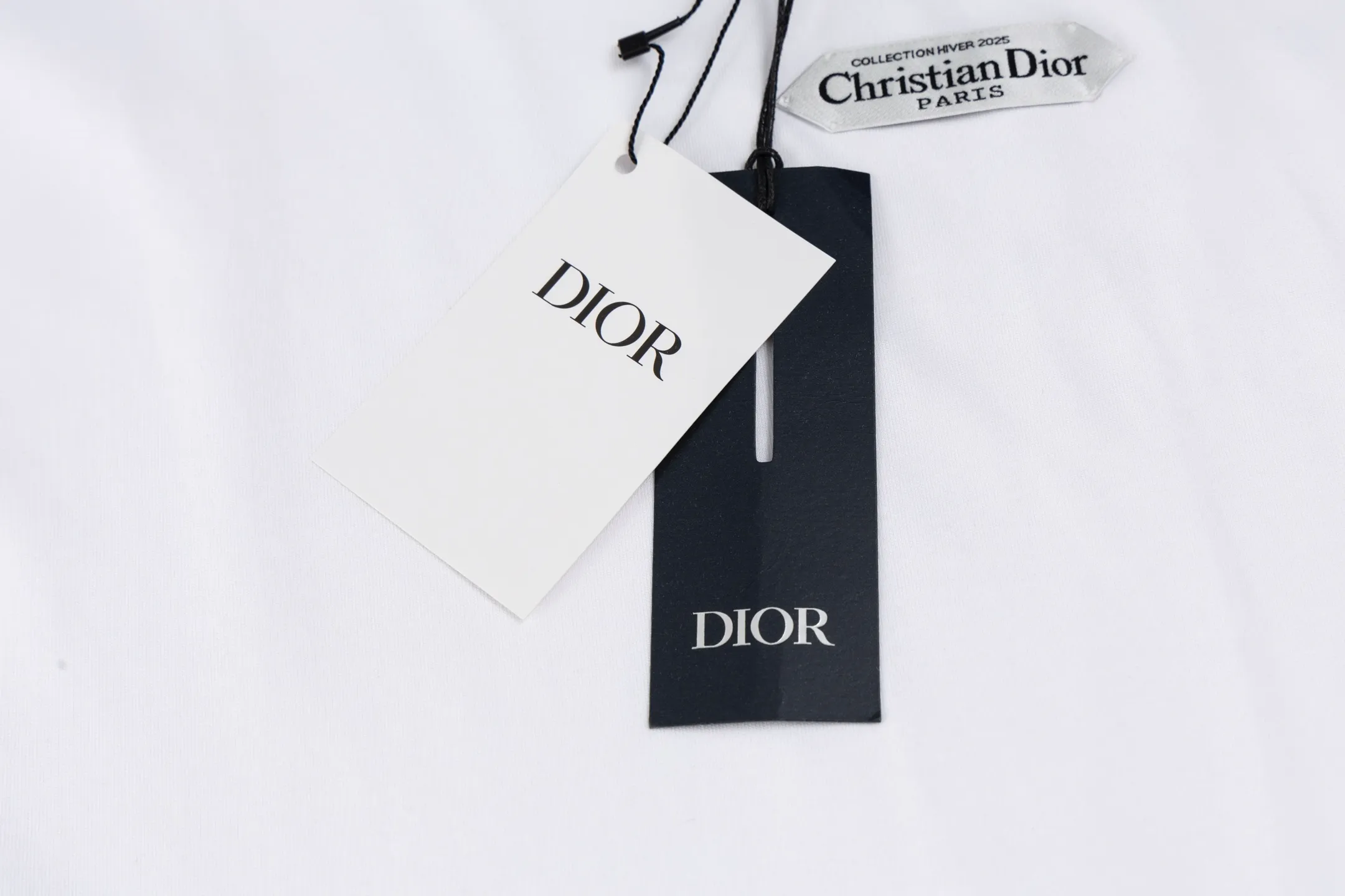 🅿️280 [Exclusive supply] CD 25FW simple label short sleeves (white) The fabric is made of 24S 185g special woven compact cotton fabric, and the rib is made of 32S 300g double yarn rib. This T-shirt is new to the 2025 winter men's collection. It is decorated with a CD Paris logo label inspired by the spirit of haute couture to enhance the style and pay tribute to the extraordinary craftsmanship of the workshop. Crafted from black cotton jersey with a ribbed crew neck and cuffs, it can be worn with track pants for a casual look. It is woven with 24-count special compact cotton yarn. The weaving process requires high standards and requires the use of advanced looms and high-quality raw materials. Specially woven compact cotton has many advantages, such as softness and comfort, good breathability, strong wrinkle resistance, good durability, etc.; it has a tighter, softer and more delicate texture and feel. The brand label on the chest is embellished as the brand's signature detail and is woven using double-sided jacquard technology; black threads are embedded in the white base, or micro-letters are formed through the density of the yarn. The edge of the label is processed by laser cutting, and there are no defects such as yarn leakage and yarn leakage. Size:XS/S/M/L