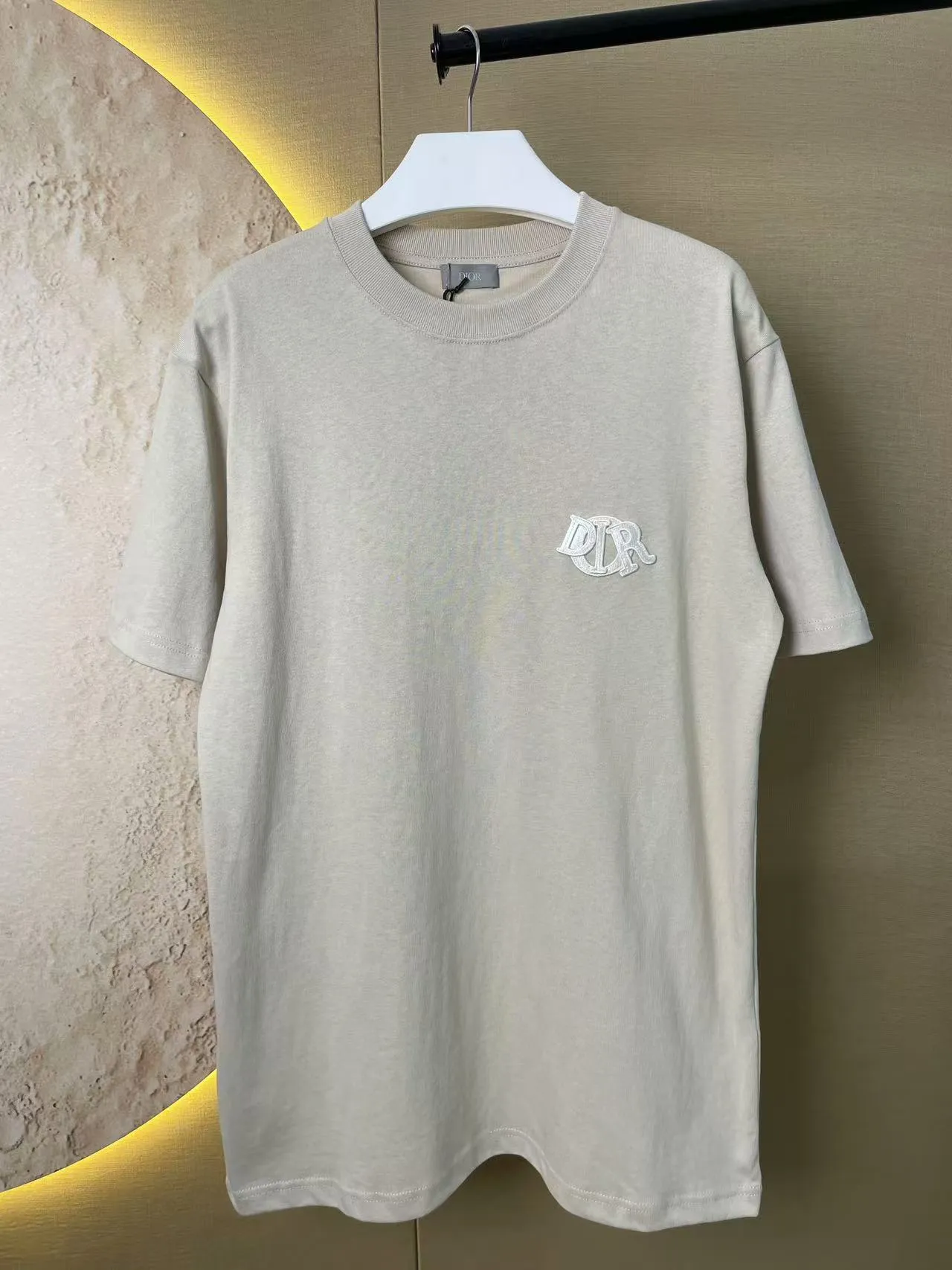 🅿️170 Dior Patch Letter Short Sleeve Color: navy blue (custom dyed new color), apricot, white, size S-XL, made of pure cotton 12S fine cotton plain weave, weight 230g. The front is decorated with contrasting logo patches and small embroidered stamps, forming a decorative and iconic embroidery product. The logo is made of imported custom-made embroidery thread, which is dyed with lustrous mercerized embroidery thread, giving it a uniform and glossy finish. The exquisite embroidery machine combines complex embroidery needlework and fine detail processing to create a three-dimensional micro-relief embroidery effect; it is also highly durable and wear-resistant. The standard round neck and short-sleeved version has a rounded arc neckline, which is suitable for various face shapes and body shapes; the sleeve length is moderate and ends just above the elbow, showing a smart and neat image. The slim fit can show off the wearer's body curves without sacrificing comfort. The collar, cuffs, hem and other parts are all sewn with fine double-needle stitching.  size：xs s m l