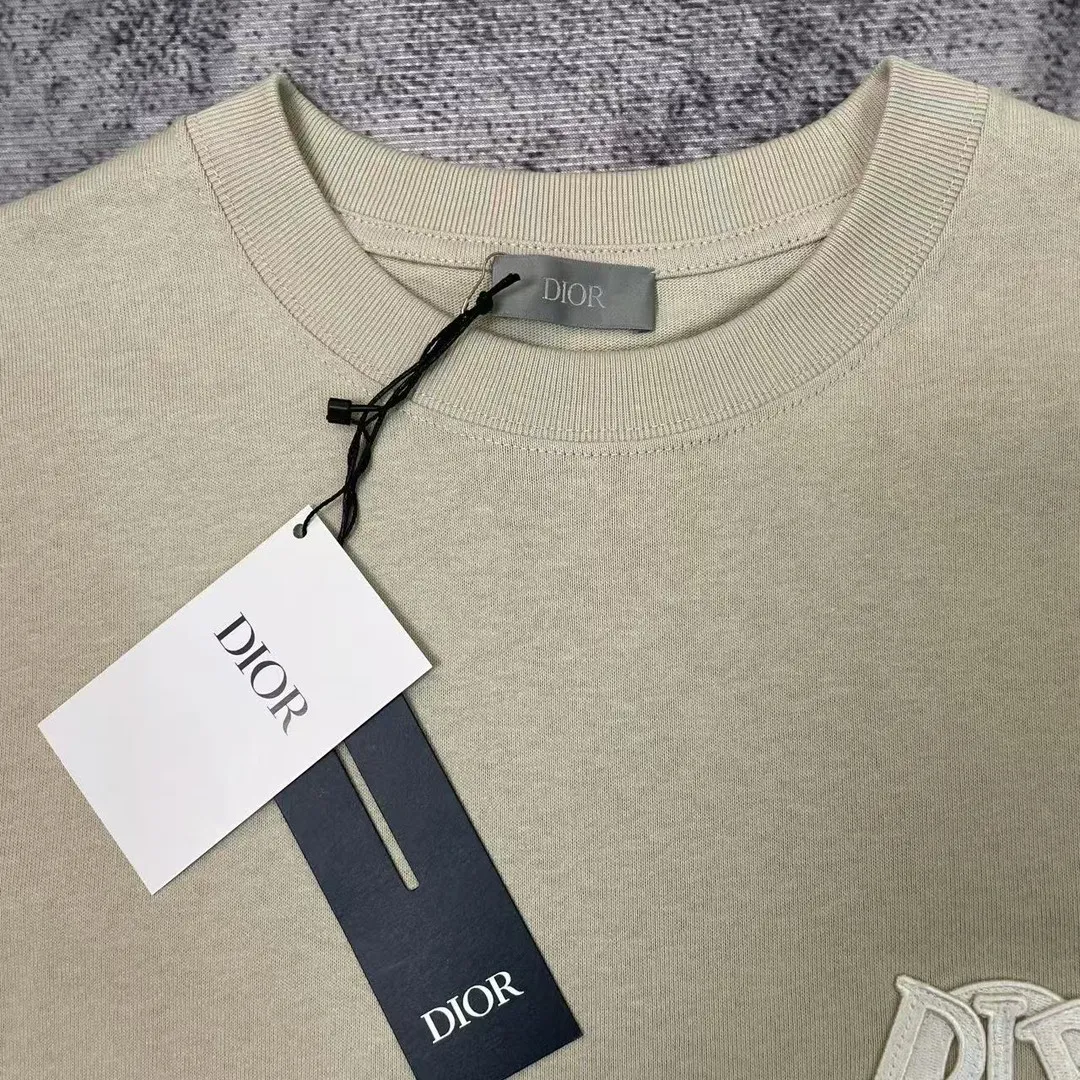 🅿️170 Dior Patch Letter Short Sleeve Color: navy blue (custom dyed new color), apricot, white, size S-XL, made of pure cotton 12S fine cotton plain weave, weight 230g. The front is decorated with contrasting logo patches and small embroidered stamps, forming a decorative and iconic embroidery product. The logo is made of imported custom-made embroidery thread, which is dyed with lustrous mercerized embroidery thread, giving it a uniform and glossy finish. The exquisite embroidery machine combines complex embroidery needlework and fine detail processing to create a three-dimensional micro-relief embroidery effect; it is also highly durable and wear-resistant. The standard round neck and short-sleeved version has a rounded arc neckline, which is suitable for various face shapes and body shapes; the sleeve length is moderate and ends just above the elbow, showing a smart and neat image. The slim fit can show off the wearer's body curves without sacrificing comfort. The collar, cuffs, hem and other parts are all sewn with fine double-needle stitching.  size：xs s m l