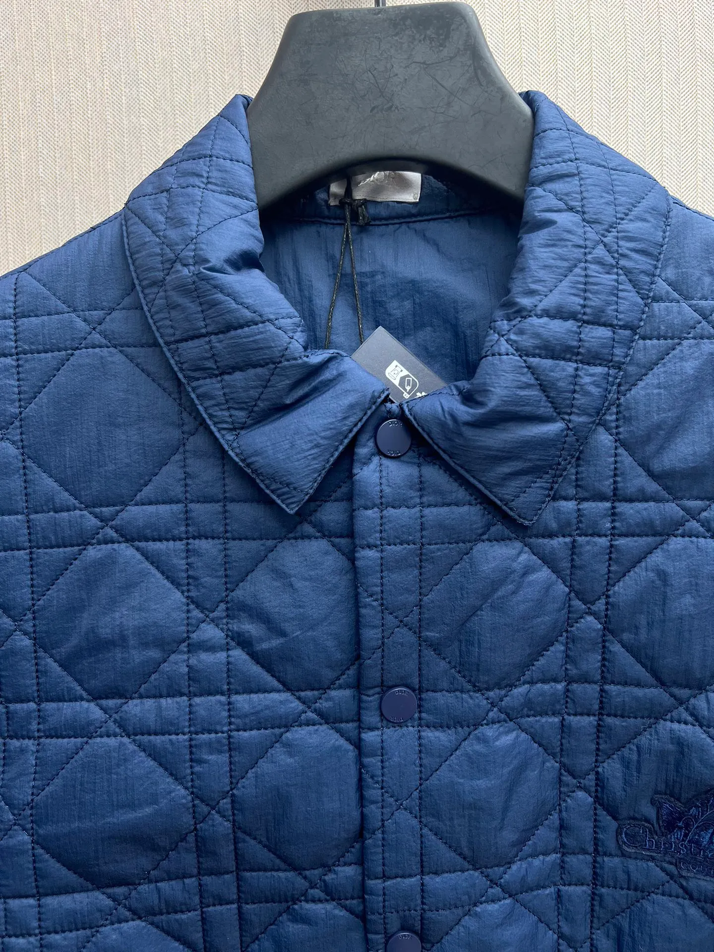 🅿️570 Dior 25ss new coat shirt highlights Christian Dior Couture embroidery and is embellished with lily of the valley flowers, paying tribute to Mr. Dior’s love for flowers. Carefully crafted from dark blue technical fabric, it's decorated with a classic cannage pattern throughout and features eye-catching side slits with metal snaps. Easily paired with jeans and a T-shirt for a chic coordinating look. Size: S.M.L.XL.