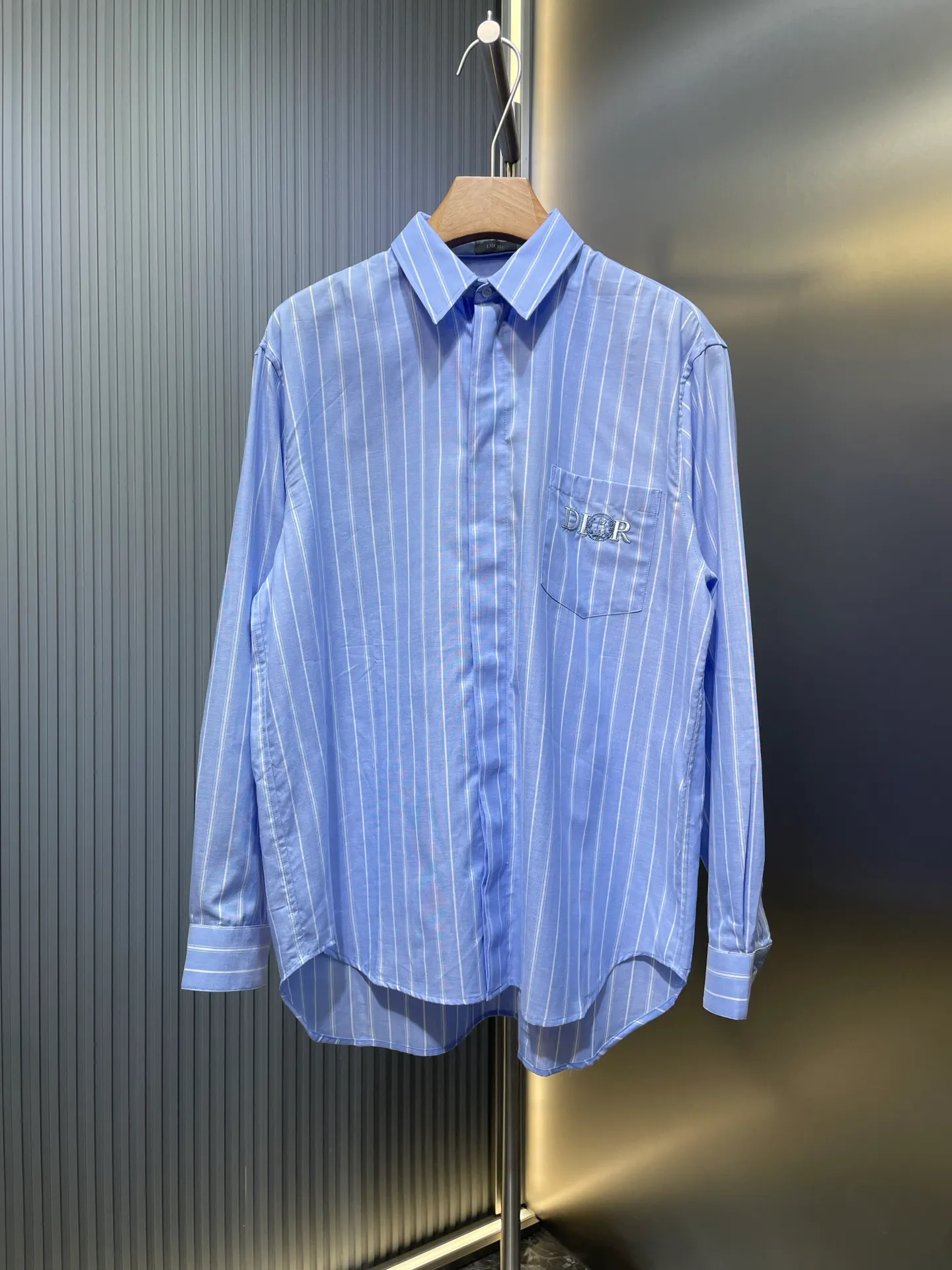 🅿️480 25ss🌟【Top Replica】The new shirt has both modern style and traditional beauty. Crafted from blue and white oxford cloth, it's finished with a striped pattern that showcases the signatures of this season's and hylton nel collaboration. A patch pocket on the chest and hidden button closure complete the design. Can be worn with everyday clothing. Code number: 39 40 41 42