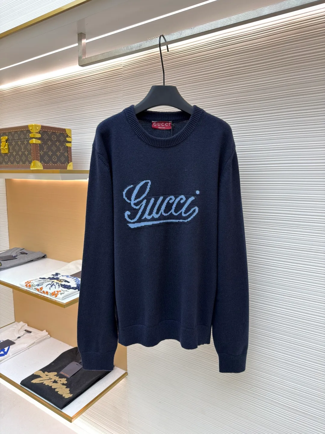 Gucci intarsia knitted wool crew neck sweater ●Original version: purchased and developed by 10024 ●Item number: 1681824-A85 ●Fabric: wool blended fabric ●Technology: knitted intarsia production ●Color: navy blue ●Version: fitted version ●Weight: about 540 grams ●Size: XS-S-M-L ●Description: This Gucci navy blue sweater is made of worsted wool blended fabric with fine flat stitch as the base, which is soft to the touch and has good warmth retention. The core logo of the garment uses contrasting jacquard technology: the light blue font is presented in a three-dimensional texture, and the strokes are smooth and delicate, forming a soft layer with the navy blue background, while retaining the recognition of the brand logo; the collar, cuffs and hem are all ribbed knitted structures, with elastic edges to ensure fit and durability. The body shape is cut with loose shoulders, and the stitching is neat without unnecessary threads. The jacquard texture and the base knitting are naturally connected, which not only reflects the fine workmanship of luxury items, but also makes it comfortable and casual for daily wear. The overall wiring is straight and delicate, the fabric is comfortable and soft, and the color is consistent without color difference. It can be matched with the same style to create a fashionable look and control various occasions. Customized accessories, complete with three standards, same style for men and women!