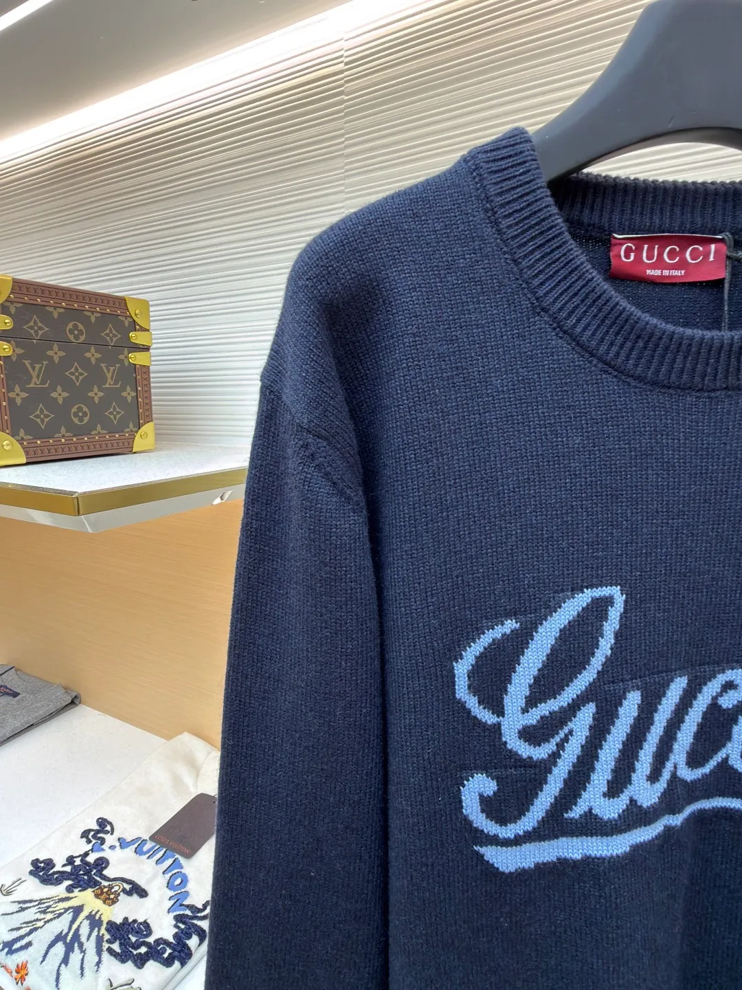 Gucci intarsia knitted wool crew neck sweater ●Original version: purchased and developed by 10024 ●Item number: 1681824-A85 ●Fabric: wool blended fabric ●Technology: knitted intarsia production ●Color: navy blue ●Version: fitted version ●Weight: about 540 grams ●Size: XS-S-M-L ●Description: This Gucci navy blue sweater is made of worsted wool blended fabric with fine flat stitch as the base, which is soft to the touch and has good warmth retention. The core logo of the garment uses contrasting jacquard technology: the light blue font is presented in a three-dimensional texture, and the strokes are smooth and delicate, forming a soft layer with the navy blue background, while retaining the recognition of the brand logo; the collar, cuffs and hem are all ribbed knitted structures, with elastic edges to ensure fit and durability. The body shape is cut with loose shoulders, and the stitching is neat without unnecessary threads. The jacquard texture and the base knitting are naturally connected, which not only reflects the fine workmanship of luxury items, but also makes it comfortable and casual for daily wear. The overall wiring is straight and delicate, the fabric is comfortable and soft, and the color is consistent without color difference. It can be matched with the same style to create a fashionable look and control various occasions. Customized accessories, complete with three standards, same style for men and women!