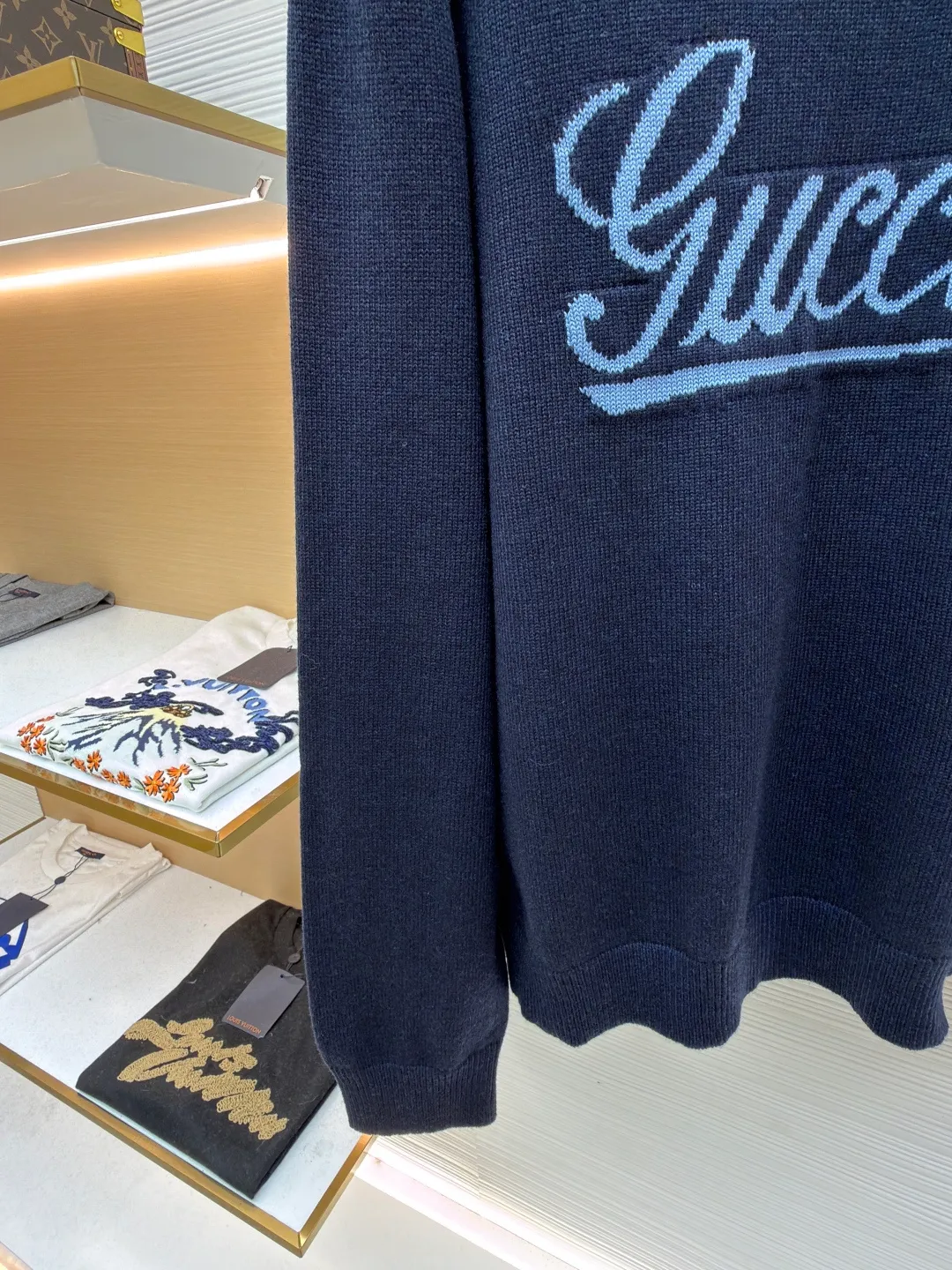 Gucci intarsia knitted wool crew neck sweater ●Original version: purchased and developed by 10024 ●Item number: 1681824-A85 ●Fabric: wool blended fabric ●Technology: knitted intarsia production ●Color: navy blue ●Version: fitted version ●Weight: about 540 grams ●Size: XS-S-M-L ●Description: This Gucci navy blue sweater is made of worsted wool blended fabric with fine flat stitch as the base, which is soft to the touch and has good warmth retention. The core logo of the garment uses contrasting jacquard technology: the light blue font is presented in a three-dimensional texture, and the strokes are smooth and delicate, forming a soft layer with the navy blue background, while retaining the recognition of the brand logo; the collar, cuffs and hem are all ribbed knitted structures, with elastic edges to ensure fit and durability. The body shape is cut with loose shoulders, and the stitching is neat without unnecessary threads. The jacquard texture and the base knitting are naturally connected, which not only reflects the fine workmanship of luxury items, but also makes it comfortable and casual for daily wear. The overall wiring is straight and delicate, the fabric is comfortable and soft, and the color is consistent without color difference. It can be matched with the same style to create a fashionable look and control various occasions. Customized accessories, complete with three standards, same style for men and women!