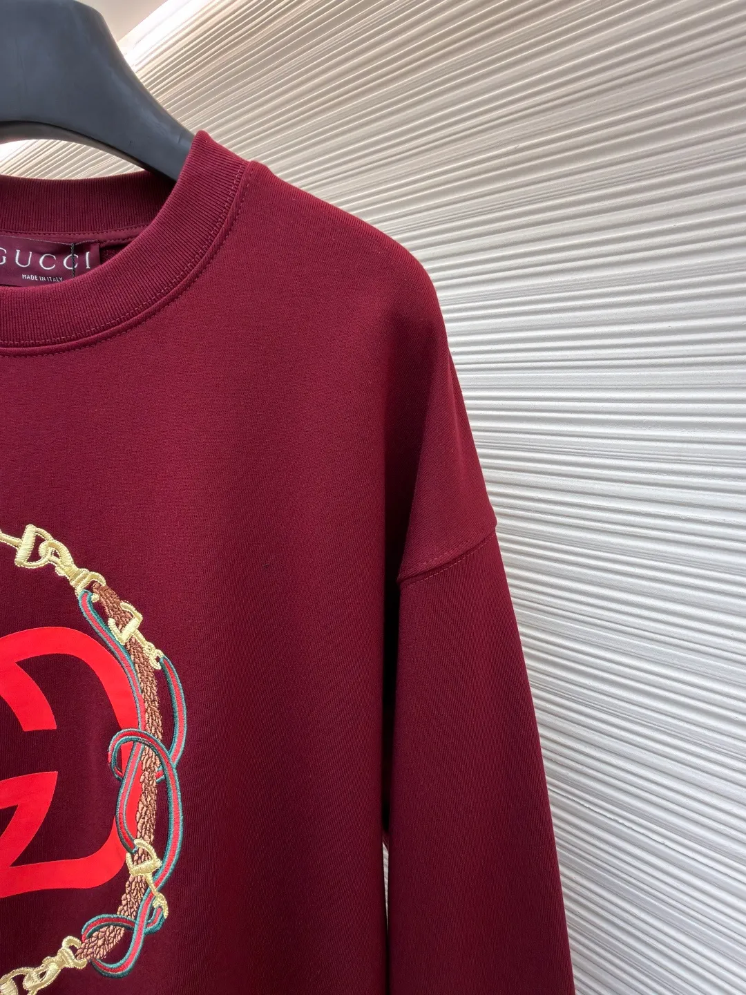 Gucci Bridle Web Round Neck Sweater ●Item No.: 1682278-A65 ●Material: 100% cotton ●Technology: Embroidery ●Color: Red ●Version: Fit ●Weight: about 690 grams ●Size: XS-S-M-L ●Description: This Gucci sweatshirt is made of high-weight combed cotton fabric. The fabric is tight and elastic, which can effectively maintain the stiffness and wearing comfort. The double G logo on the front adopts multi-layer embroidery technology, with gold thread to outline the outline, red and green velvet thread to fill the texture, and metallic chain stripe pattern appliqué. The stitches are fine and even, and each embroidery is precisely positioned to form a three-dimensional contrast with the fabric texture. The body is cut according to the loose shoulder design, and the shoulder line splicing adopts overlock stitching technology to reduce friction when wearing; the cuffs and hem are edged with ribs of the same color, which has long-lasting elasticity and is not easy to loosen. Sizes from XS to L are all standardized plate making, with increasing gradients in dimensions such as garment length and shoulder width. The stitching process uses a combination of flat seams and overlock seams to ensure the firmness of the garments and the exquisiteness of details. The overall craftsmanship combines the brand's iconic design with practical wearing performance. The overall wiring is straight and delicate, the fabric is comfortable and soft, and the color is consistent without color difference. It can be matched with the same style to create a fashionable look and control various occasions. Customized accessories, complete with three standards, same style for men and women!