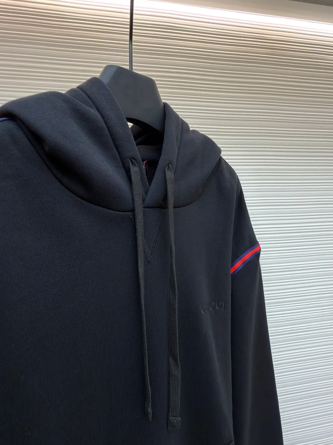 Gucci black webbing hooded sweatshirt ●Item number: 1681424-B10 ●Material: cotton terry fabric ●Technology: embroidery production ●Color: black ●Version: fitted version ●Weight: about 695 grams ●Size: S-M-L ●Description: This sweatshirt is made of high-density waffle velvet fabric, which feels thick and has good warmth retention. The hooded design adopts three-dimensional tailoring and drawstring technology. The hood is stiff and can be freely adjusted for tightness. The red and blue webbing on the shoulders uses inlay sewing technology to form a sharp visual contrast with the black fabric, and the lines are smooth and firm. The brand logo on the chest uses high-density embroidery technology, and the letter texture is delicate and closely adheres to the fabric. The kangaroo pocket is made of one-piece molding technology, with flat edges and convenient storage. The cuffs and hem ribs are made of high-elastic knitting technology, which closely fits the body and has excellent elasticity. The overall cut is a loose, dropped-shoulder version, and the multi-piece structure is spliced ​​to create a casual and trendy wearing effect, while ensuring comfort and freedom during movement. It is a fashionable item that combines the brand's classic elements with casual sweatshirt technology, and has both texture and practicality. The overall wiring is straight and delicate, the fabric is comfortable and soft, and the color is consistent without color difference. It can be matched with the same style to create a fashionable look and control various occasions. Customized accessories, complete with three standards, same style for men and women!