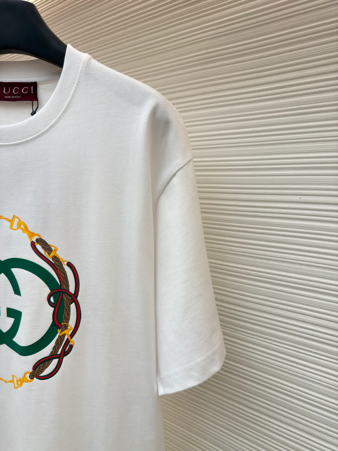 Gucci bridle webbing round neck short sleeves ●Original version: purchased and developed by 5270 ●Item number: 1682232-A00 ●Fabric: fine velvet knitted cotton fabric ●Technology: glue printing ●Color: white ●Version: fitted version ●Weight: about 285 grams ●Size: XS-S-M-L ●Description: 5S special woven compact fine velvet knitted cotton, weight 230g/㎡; paired with 32S high count and weight 1x1 rib, weight 340g/㎡. Ribbing is used on the collar to ensure excellent elastic recovery and deformation resistance of the collar. The fabric adopts compact spinning technology in the spinning process, which significantly reduces yarn hairiness, making the fabric structure denser, the surface smoother, and the pilling resistance better; fine velvet knitted fabric means that the fabric has been lightly sanded or raised. It feels close to ultra-fine suede; it has a soft and waxy skin-friendly feel. The weight of 230g is medium to heavy, which gives the T-shirt good stiffness and drape, ensuring the texture of the garment and the silhouette that is not prone to collapse. The pattern adopts environmentally friendly elastic glue printing technology. The special environmentally friendly water-based elastic slurry is transferred to the surface of the fabric through a fine silk screen, and then baked and solidified at high temperature. Its elastic properties ensure that the printed pattern can stretch with the fabric without cracking, and has excellent durability; the printed area presents a semi-matte uniform coating effect with high color saturation. It feels soft to the touch and has no obvious film lumps, maintaining the original breathability and comfort of the fabric. The overall wiring is straight and delicate, the fabric is comfortable and soft, and the color is consistent without color difference. It can be matched with the same style to create a fashionable look and control various occasions. Customized accessories, complete with three standards, same style for men and women!