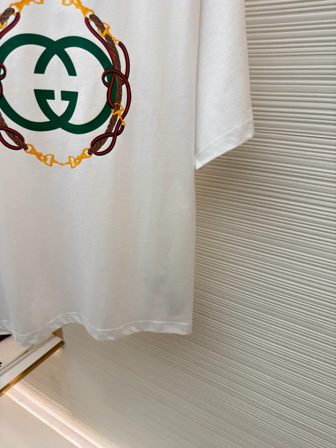 Gucci bridle webbing round neck short sleeves ●Original version: purchased and developed by 5270 ●Item number: 1682232-A00 ●Fabric: fine velvet knitted cotton fabric ●Technology: glue printing ●Color: white ●Version: fitted version ●Weight: about 285 grams ●Size: XS-S-M-L ●Description: 5S special woven compact fine velvet knitted cotton, weight 230g/㎡; paired with 32S high count and weight 1x1 rib, weight 340g/㎡. Ribbing is used on the collar to ensure excellent elastic recovery and deformation resistance of the collar. The fabric adopts compact spinning technology in the spinning process, which significantly reduces yarn hairiness, making the fabric structure denser, the surface smoother, and the pilling resistance better; fine velvet knitted fabric means that the fabric has been lightly sanded or raised. It feels close to ultra-fine suede; it has a soft and waxy skin-friendly feel. The weight of 230g is medium to heavy, which gives the T-shirt good stiffness and drape, ensuring the texture of the garment and the silhouette that is not prone to collapse. The pattern adopts environmentally friendly elastic glue printing technology. The special environmentally friendly water-based elastic slurry is transferred to the surface of the fabric through a fine silk screen, and then baked and solidified at high temperature. Its elastic properties ensure that the printed pattern can stretch with the fabric without cracking, and has excellent durability; the printed area presents a semi-matte uniform coating effect with high color saturation. It feels soft to the touch and has no obvious film lumps, maintaining the original breathability and comfort of the fabric. The overall wiring is straight and delicate, the fabric is comfortable and soft, and the color is consistent without color difference. It can be matched with the same style to create a fashionable look and control various occasions. Customized accessories, complete with three standards, same style for men and women!