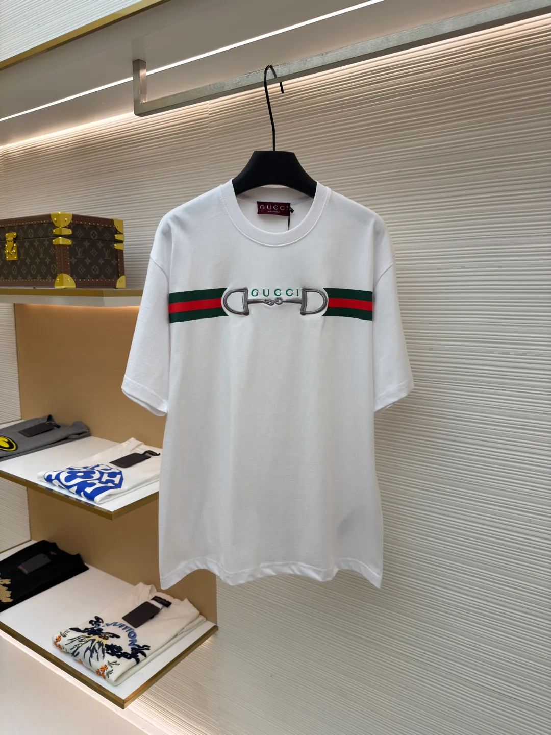 Gucci Lock Round Neck Short Sleeves ●Original version: Purchased and developed by 3031 ●Item number: 1682127-A05 ●Fabric: fine velvet knitted cotton fabric ●Technology: embroidery production ●Color: white ●Version: fitted version ●Weight: about 280 grams ●Size: XS-S-M-L ●Description: Made of 15S special woven compact cotton fine velvet knitted fabric with a weight of 230g/㎡; paired with 32S high count and high weight 1x1 rib, with a weight of 340g/㎡. Ribbing is used on the collar to ensure excellent elastic recovery and deformation resistance of the collar. The fabric uses compact spinning technology to effectively reduce yarn hairiness, making the fabric structure tighter, the surface smoother, and the pilling resistance better. The weight of 230g is medium to heavy, which gives the T-shirt good stiffness and drape, and is not easy to collapse, ensuring the texture of high-end ready-to-wear. The fine velvet knitted fabric has been lightly brushed or raised, giving it a softer, waxier skin-friendly feel than ordinary plain cotton. Environmentally friendly elastic glue printing uses water-based environmentally friendly slurry and polymer cross-linking technology to make the pattern have excellent elasticity and can expand and contract simultaneously with the fabric without cracking. The printing layer has a matte texture, is soft and smooth to the touch, and does not have the hardening feel of traditional offset printing, while maintaining the breathability of the fabric. It has strong color coverage, is washable and wear-resistant, and takes into account both visual performance and wearing comfort. Core-covered three-dimensional embroidery is made by pre-inserting a foam core material under the high-density embroidery layer as a filling base, and then fully covering it with embroidery threads. The process can create a three-dimensional pattern with highly pronounced convexities and rounded and full edges, and the visual effect is extremely impactful. The overall wiring is straight and delicate, the fabric is comfortable and soft, and the color is consistent without color difference. It can be matched with the same style to create a fashionable look and control various occasions. Customized accessories, complete with three standards, same style for men and women!