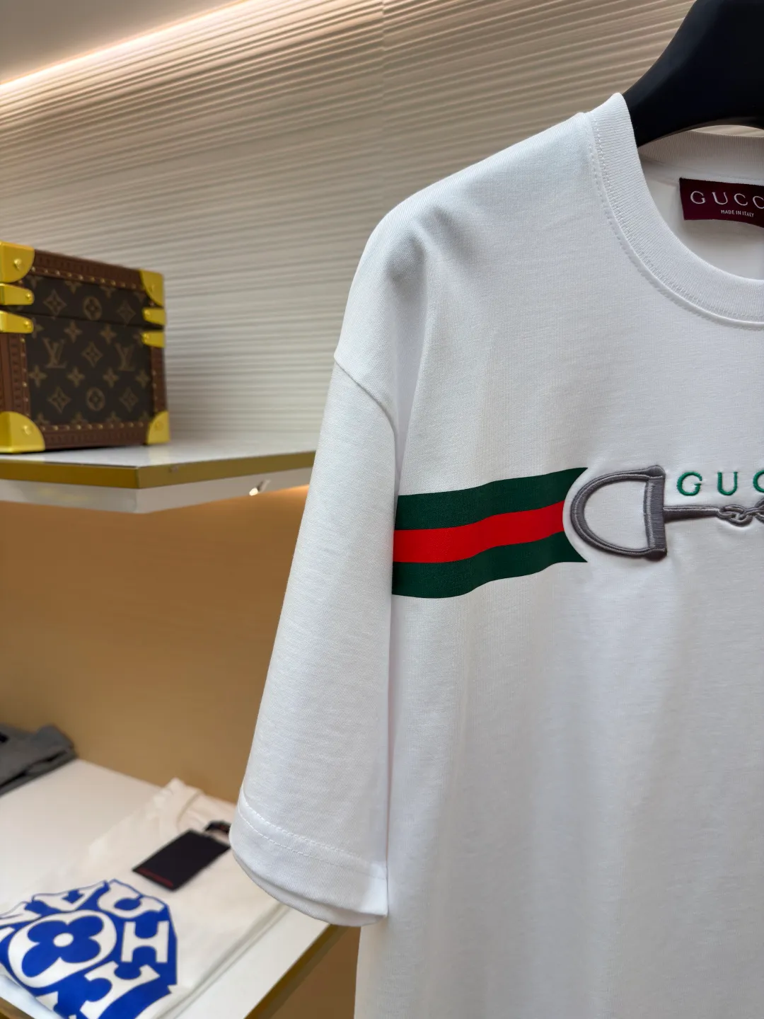 Gucci Lock Round Neck Short Sleeves ●Original version: Purchased and developed by 3031 ●Item number: 1682127-A05 ●Fabric: fine velvet knitted cotton fabric ●Technology: embroidery production ●Color: white ●Version: fitted version ●Weight: about 280 grams ●Size: XS-S-M-L ●Description: Made of 15S special woven compact cotton fine velvet knitted fabric with a weight of 230g/㎡; paired with 32S high count and high weight 1x1 rib, with a weight of 340g/㎡. Ribbing is used on the collar to ensure excellent elastic recovery and deformation resistance of the collar. The fabric uses compact spinning technology to effectively reduce yarn hairiness, making the fabric structure tighter, the surface smoother, and the pilling resistance better. The weight of 230g is medium to heavy, which gives the T-shirt good stiffness and drape, and is not easy to collapse, ensuring the texture of high-end ready-to-wear. The fine velvet knitted fabric has been lightly brushed or raised, giving it a softer, waxier skin-friendly feel than ordinary plain cotton. Environmentally friendly elastic glue printing uses water-based environmentally friendly slurry and polymer cross-linking technology to make the pattern have excellent elasticity and can expand and contract simultaneously with the fabric without cracking. The printing layer has a matte texture, is soft and smooth to the touch, and does not have the hardening feel of traditional offset printing, while maintaining the breathability of the fabric. It has strong color coverage, is washable and wear-resistant, and takes into account both visual performance and wearing comfort. Core-covered three-dimensional embroidery is made by pre-inserting a foam core material under the high-density embroidery layer as a filling base, and then fully covering it with embroidery threads. The process can create a three-dimensional pattern with highly pronounced convexities and rounded and full edges, and the visual effect is extremely impactful. The overall wiring is straight and delicate, the fabric is comfortable and soft, and the color is consistent without color difference. It can be matched with the same style to create a fashionable look and control various occasions. Customized accessories, complete with three standards, same style for men and women!