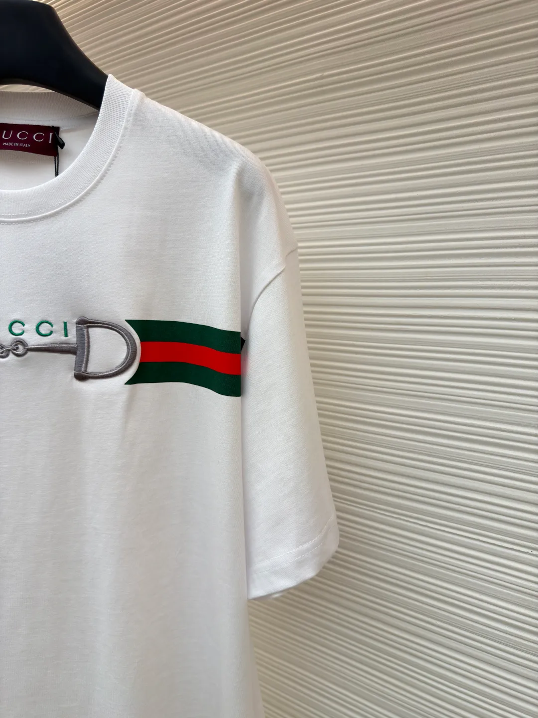 Gucci Lock Round Neck Short Sleeves ●Original version: Purchased and developed by 3031 ●Item number: 1682127-A05 ●Fabric: fine velvet knitted cotton fabric ●Technology: embroidery production ●Color: white ●Version: fitted version ●Weight: about 280 grams ●Size: XS-S-M-L ●Description: Made of 15S special woven compact cotton fine velvet knitted fabric with a weight of 230g/㎡; paired with 32S high count and high weight 1x1 rib, with a weight of 340g/㎡. Ribbing is used on the collar to ensure excellent elastic recovery and deformation resistance of the collar. The fabric uses compact spinning technology to effectively reduce yarn hairiness, making the fabric structure tighter, the surface smoother, and the pilling resistance better. The weight of 230g is medium to heavy, which gives the T-shirt good stiffness and drape, and is not easy to collapse, ensuring the texture of high-end ready-to-wear. The fine velvet knitted fabric has been lightly brushed or raised, giving it a softer, waxier skin-friendly feel than ordinary plain cotton. Environmentally friendly elastic glue printing uses water-based environmentally friendly slurry and polymer cross-linking technology to make the pattern have excellent elasticity and can expand and contract simultaneously with the fabric without cracking. The printing layer has a matte texture, is soft and smooth to the touch, and does not have the hardening feel of traditional offset printing, while maintaining the breathability of the fabric. It has strong color coverage, is washable and wear-resistant, and takes into account both visual performance and wearing comfort. Core-covered three-dimensional embroidery is made by pre-inserting a foam core material under the high-density embroidery layer as a filling base, and then fully covering it with embroidery threads. The process can create a three-dimensional pattern with highly pronounced convexities and rounded and full edges, and the visual effect is extremely impactful. The overall wiring is straight and delicate, the fabric is comfortable and soft, and the color is consistent without color difference. It can be matched with the same style to create a fashionable look and control various occasions. Customized accessories, complete with three standards, same style for men and women!
