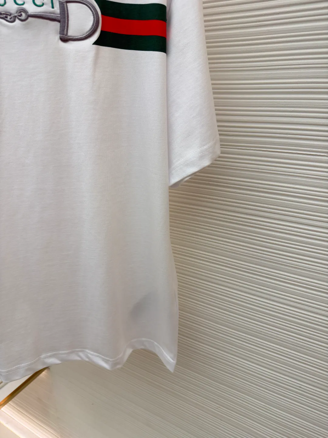 Gucci Lock Round Neck Short Sleeves ●Original version: Purchased and developed by 3031 ●Item number: 1682127-A05 ●Fabric: fine velvet knitted cotton fabric ●Technology: embroidery production ●Color: white ●Version: fitted version ●Weight: about 280 grams ●Size: XS-S-M-L ●Description: Made of 15S special woven compact cotton fine velvet knitted fabric with a weight of 230g/㎡; paired with 32S high count and high weight 1x1 rib, with a weight of 340g/㎡. Ribbing is used on the collar to ensure excellent elastic recovery and deformation resistance of the collar. The fabric uses compact spinning technology to effectively reduce yarn hairiness, making the fabric structure tighter, the surface smoother, and the pilling resistance better. The weight of 230g is medium to heavy, which gives the T-shirt good stiffness and drape, and is not easy to collapse, ensuring the texture of high-end ready-to-wear. The fine velvet knitted fabric has been lightly brushed or raised, giving it a softer, waxier skin-friendly feel than ordinary plain cotton. Environmentally friendly elastic glue printing uses water-based environmentally friendly slurry and polymer cross-linking technology to make the pattern have excellent elasticity and can expand and contract simultaneously with the fabric without cracking. The printing layer has a matte texture, is soft and smooth to the touch, and does not have the hardening feel of traditional offset printing, while maintaining the breathability of the fabric. It has strong color coverage, is washable and wear-resistant, and takes into account both visual performance and wearing comfort. Core-covered three-dimensional embroidery is made by pre-inserting a foam core material under the high-density embroidery layer as a filling base, and then fully covering it with embroidery threads. The process can create a three-dimensional pattern with highly pronounced convexities and rounded and full edges, and the visual effect is extremely impactful. The overall wiring is straight and delicate, the fabric is comfortable and soft, and the color is consistent without color difference. It can be matched with the same style to create a fashionable look and control various occasions. Customized accessories, complete with three standards, same style for men and women!