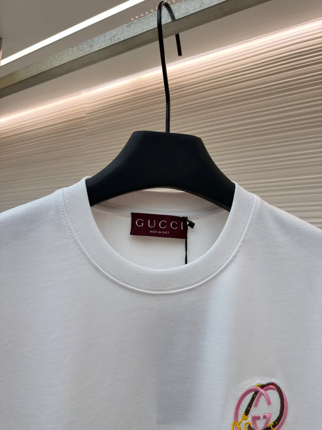 Gucci horseshoe buckle embroidered round neck short sleeves ●Item number: 1682116-A00 ●Material: fine velvet knitted cotton fabric ●Technology: embroidery production ●Color: white ●Version: fitted version ●Weight: about 270 grams ●Size: XS-S-M-L ●Description: Made of 15S special woven compact cotton fine velvet knitted fabric with a weight of 230g/㎡; paired with 32S high count and high weight 1x1 rib, with a weight of 340g/㎡. Ribbing is used on the collar to ensure excellent elastic recovery and deformation resistance of the collar. The fabric uses compact spinning technology to effectively reduce yarn hairiness, making the fabric structure tighter, the surface smoother, and the pilling resistance better. The weight of 230g is medium to heavy, which gives the T-shirt good stiffness and drape, and is not easy to collapse, ensuring the texture of high-end ready-to-wear. The fine velvet knitted fabric has been lightly brushed or raised, giving it a softer, waxier skin-friendly feel than ordinary plain cotton. Using multi-color fine flat embroidery technology, the pattern is completely covered and filled with extremely high-density stitches using embroidery threads of multiple colors according to the design artwork. Every detail and color transition of the complex pattern is accurately restored, so that the shape, light, shadow, and texture of the double-G interlocking webbing and stirrups are clearly presented. The final embroidery surface is flat, smooth, and full, with clear edges, and has a delicate effect and micro-three-dimensional effect similar to gongbi painting. The overall wiring is straight and delicate, the fabric is comfortable and soft, and the color is consistent without color difference. It can be matched with the same style to create a fashionable look and control various occasions. Customized accessories, complete with three standards, same style for men and women!