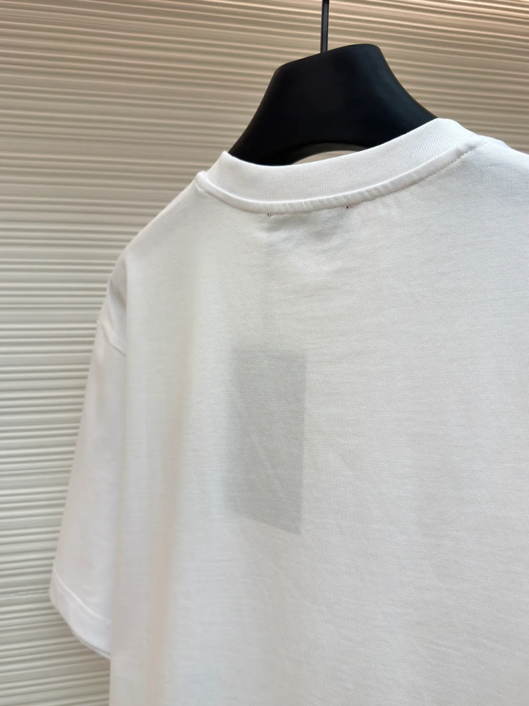 Gucci horseshoe buckle embroidered round neck short sleeves ●Item number: 1682116-A00 ●Material: fine velvet knitted cotton fabric ●Technology: embroidery production ●Color: white ●Version: fitted version ●Weight: about 270 grams ●Size: XS-S-M-L ●Description: Made of 15S special woven compact cotton fine velvet knitted fabric with a weight of 230g/㎡; paired with 32S high count and high weight 1x1 rib, with a weight of 340g/㎡. Ribbing is used on the collar to ensure excellent elastic recovery and deformation resistance of the collar. The fabric uses compact spinning technology to effectively reduce yarn hairiness, making the fabric structure tighter, the surface smoother, and the pilling resistance better. The weight of 230g is medium to heavy, which gives the T-shirt good stiffness and drape, and is not easy to collapse, ensuring the texture of high-end ready-to-wear. The fine velvet knitted fabric has been lightly brushed or raised, giving it a softer, waxier skin-friendly feel than ordinary plain cotton. Using multi-color fine flat embroidery technology, the pattern is completely covered and filled with extremely high-density stitches using embroidery threads of multiple colors according to the design artwork. Every detail and color transition of the complex pattern is accurately restored, so that the shape, light, shadow, and texture of the double-G interlocking webbing and stirrups are clearly presented. The final embroidery surface is flat, smooth, and full, with clear edges, and has a delicate effect and micro-three-dimensional effect similar to gongbi painting. The overall wiring is straight and delicate, the fabric is comfortable and soft, and the color is consistent without color difference. It can be matched with the same style to create a fashionable look and control various occasions. Customized accessories, complete with three standards, same style for men and women!