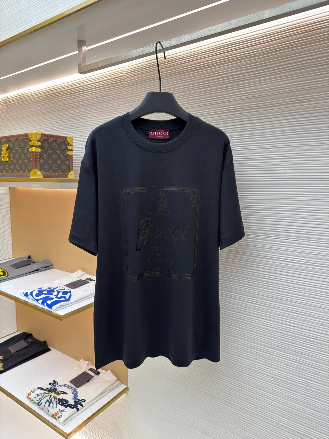 Gucci Buddha City printed round neck short sleeves ●Original version: purchased and developed by 5039 ●Item number: 1682281-A00 ●Fabric: soft knitted cotton fabric ●Technology: Glue printing production ●Color: black ●Version: fitted version ●Weight: about 235 grams ●Size: XS-S-M-L ●Description: This product is made of 60-count single-yarn double-sided knitted cotton with a weight of 170g/㎡; the neckline and other parts are matched with 32-count double-yarn ribbing. The high weight ensures a stable collar shape. 60 counts is an extremely high count, which means the yarn is extremely fine, which directly gives the fabric an extraordinary delicate, silky and soft touch. The front and back sides of the double-sided fabric have the same texture, which is uniform, thin and elastic. The weight of 170g is lightweight, ensuring the T-shirt is extremely light, breathable and drapey. It is almost invisible when worn and is very suitable for early spring. The color of the fabric is soft and high-end, which further enhances the exquisite texture of the fabric. The direct expression of the printing collection elements uses the environmentally friendly elastic thick plate bright glue printing process to place such a three-dimensional, bright, and highly present slogan printing on the simple sweater. This is a high-end special printing technology. Thick plate means that the slurry is accumulated thickly, which can form an obvious three-dimensional effect; after the bright slurry is cured, the surface will show a high-gloss glossy effect; the slurry itself is elastic and can stretch with the fabric. The special environmentally friendly elastic bright slurry is transferred through thick coating on the screen and then solidified at high temperature. Create a brand slogan pattern with significant 3D raised texture, mirror-like luster, and strong stretch resistance. To the touch, the pattern area has obvious stiff bulges and a smooth lacquered surface, which forms a strong contrast with the extremely soft fabric base and has a strong visual impact. The overall wiring is straight and delicate, the fabric is comfortable and soft, and the color is consistent without color difference. It can be matched with the same style to create a fashionable look and control various occasions. Customized accessories, complete with three standards, same style for men and women!